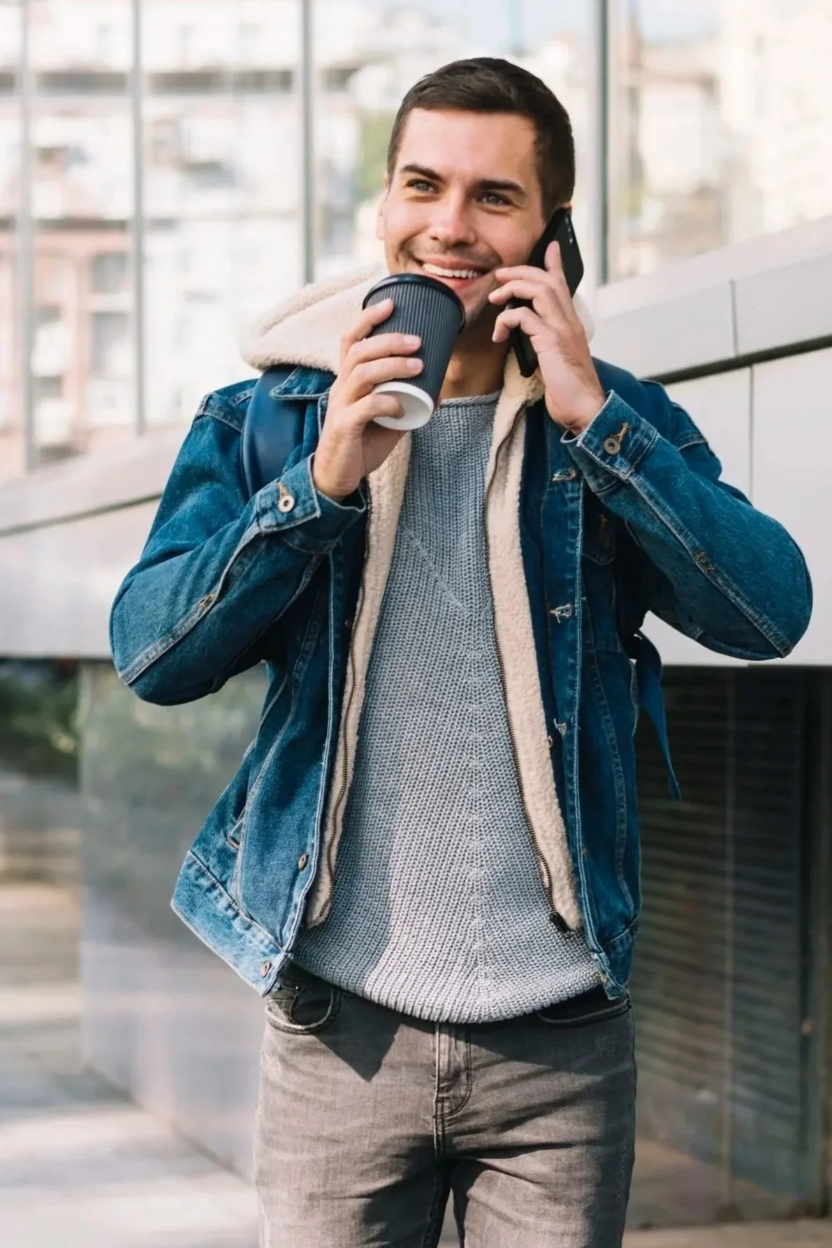 Young man holding a coffee cup in an urban setting