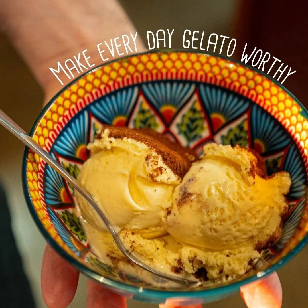 A colorful bowl with a decorative pattern containing three scoops of vanilla ice cream topped with cocoa powder. Text on the image reads, 'Make every day gelato worthy.' PepeNero Pizza Restaurant