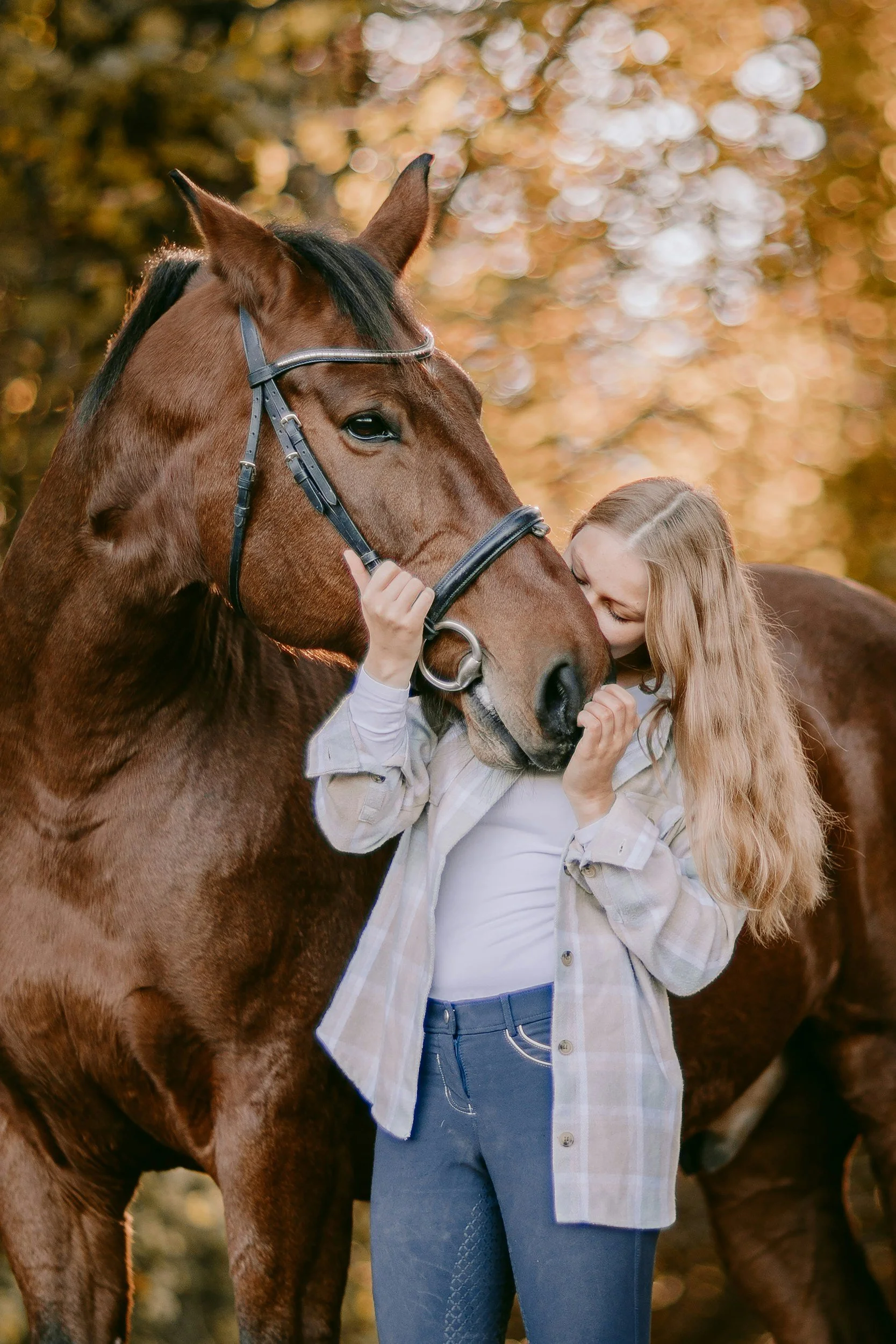 Blond girl kissing brown horse