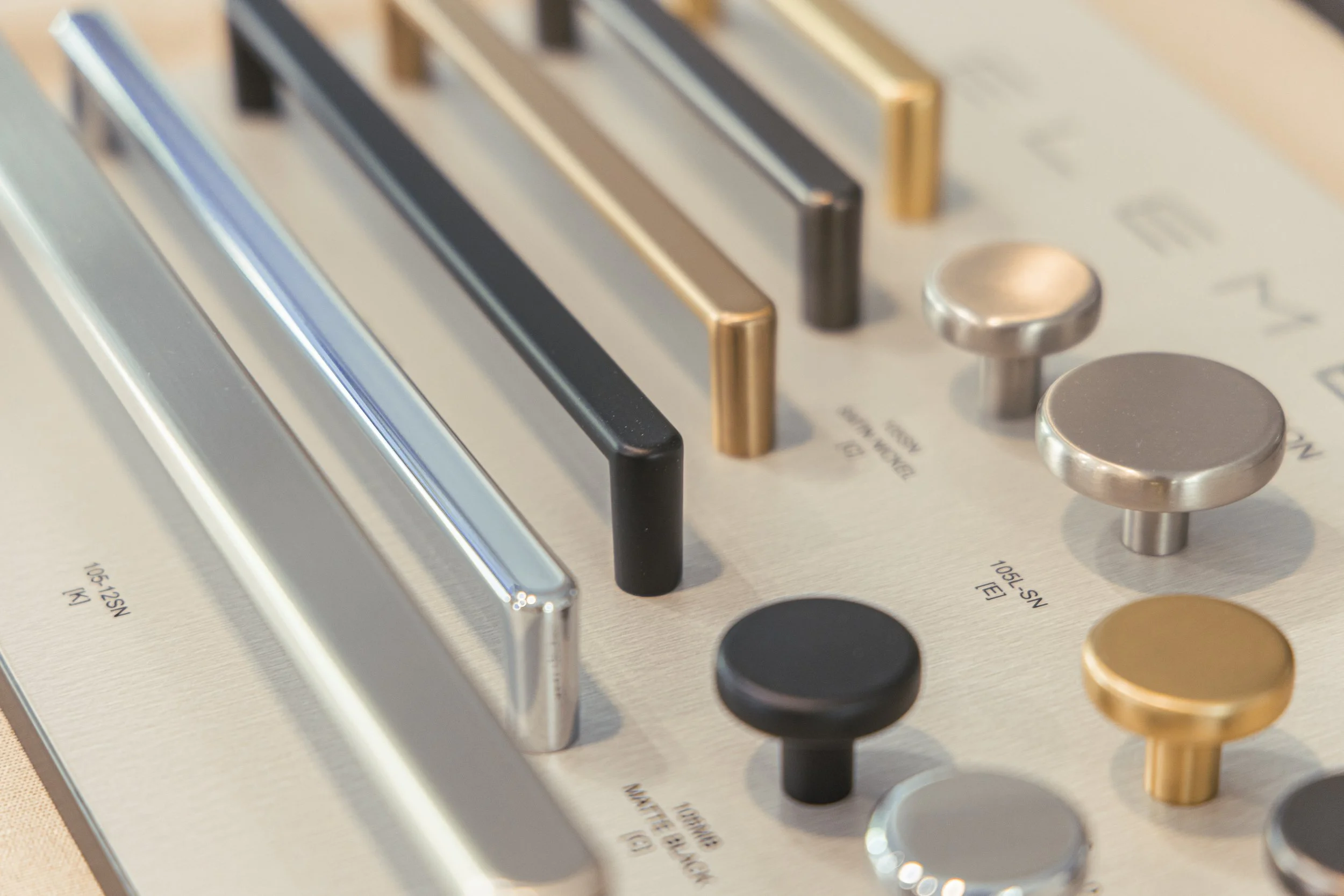 Close-up of an audio mixing console with faders, knobs, and sliders in various metallic and black finishes.