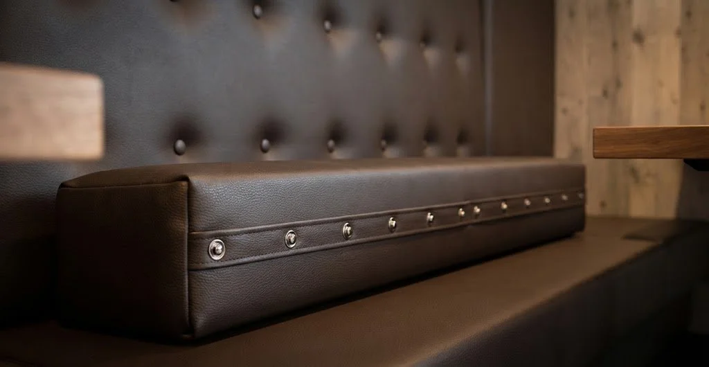 A custom leather booth or banquette seat featuring tufted button detailing along the backrest and a clean, tailored finish.
