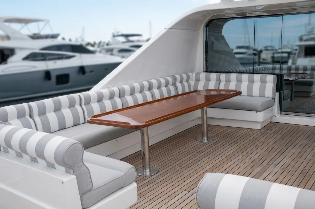 Custom grey-and-white striped marine salon seating and yacht dining table upholstery handcrafted in Fort Lauderdale by London Stitchery.