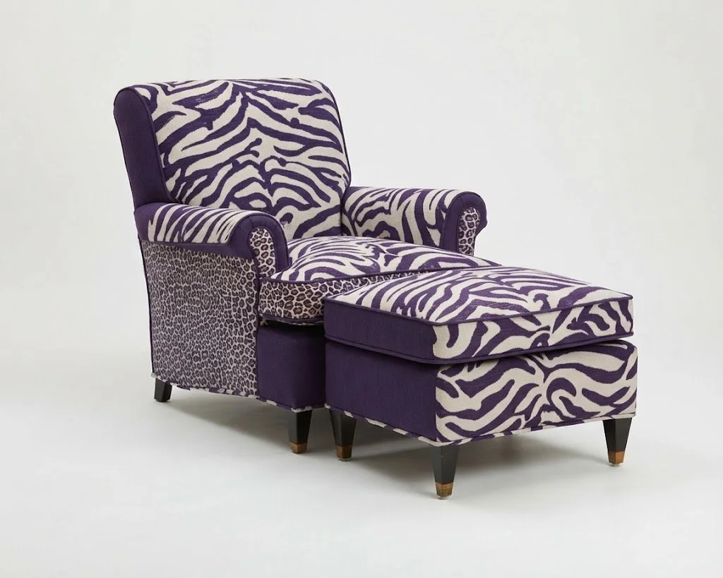 Custom Upholstered Chaise & Ottoman: Masterfully reupholstered featuring a bold zebra print statement fabric, contrasting trim, and dark tapered wood legs.
