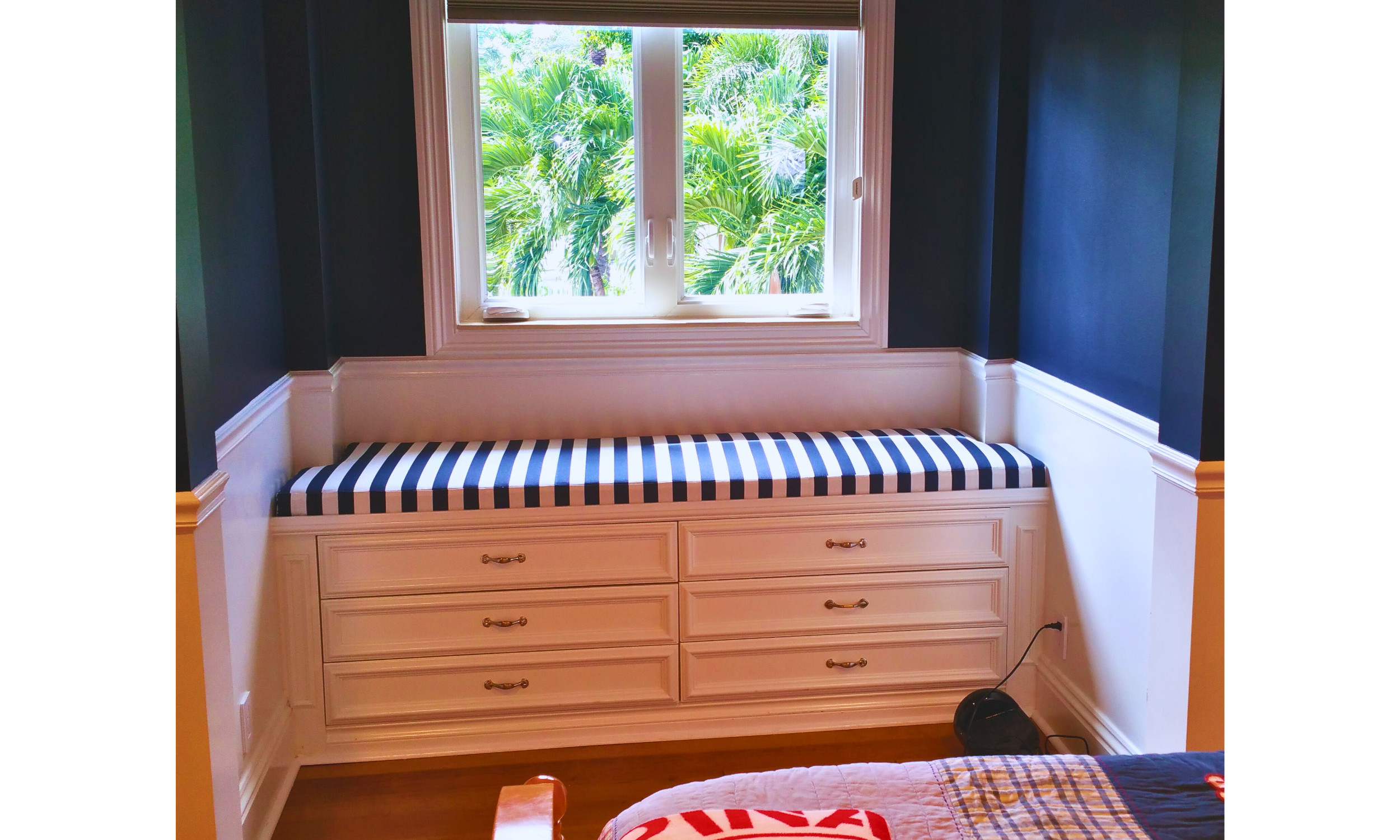  A perfectly fitted cushion, featuring nautical stripes - adds a touch of maritime elegance to this built-in window seat.