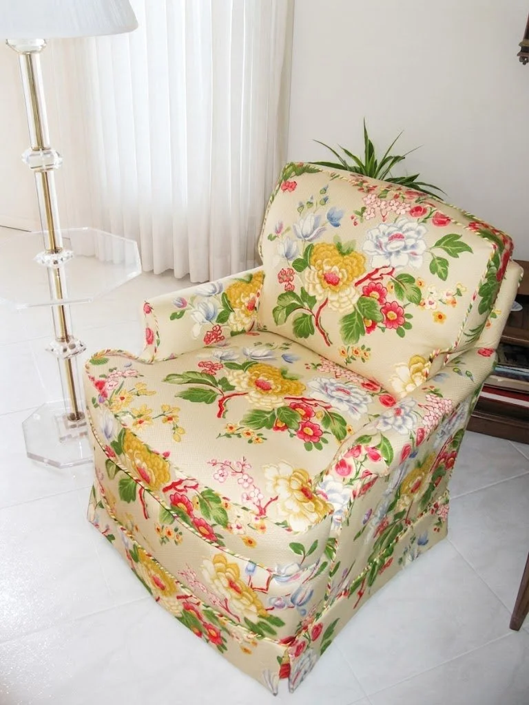 Custom-upholstered floral print armchair featuring a vibrant botanical pattern, elegant skirt detail, and expert ta