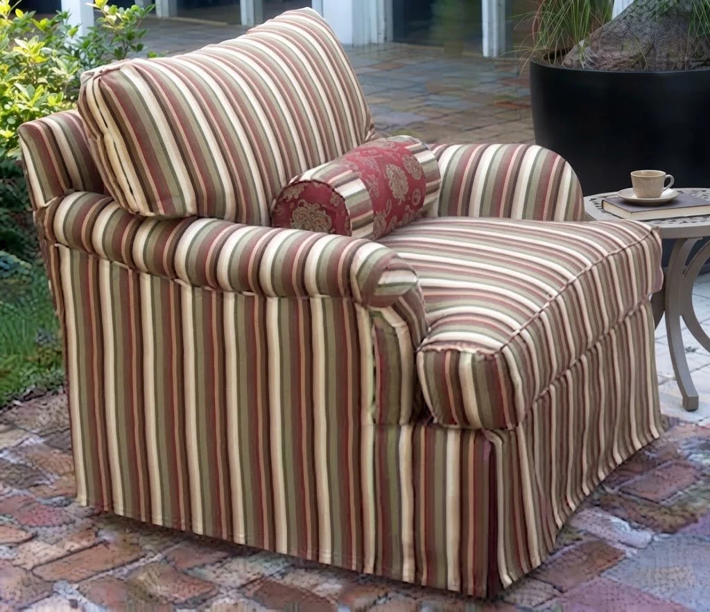 Custom-upholstered classic striped accent armchair featuring a matching bolster pillow and a tailored slipcover drap