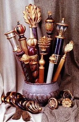 Detailed display of luxury drapery finials in various metallic finishes and patterns, showcasing custom hardware options for drapes