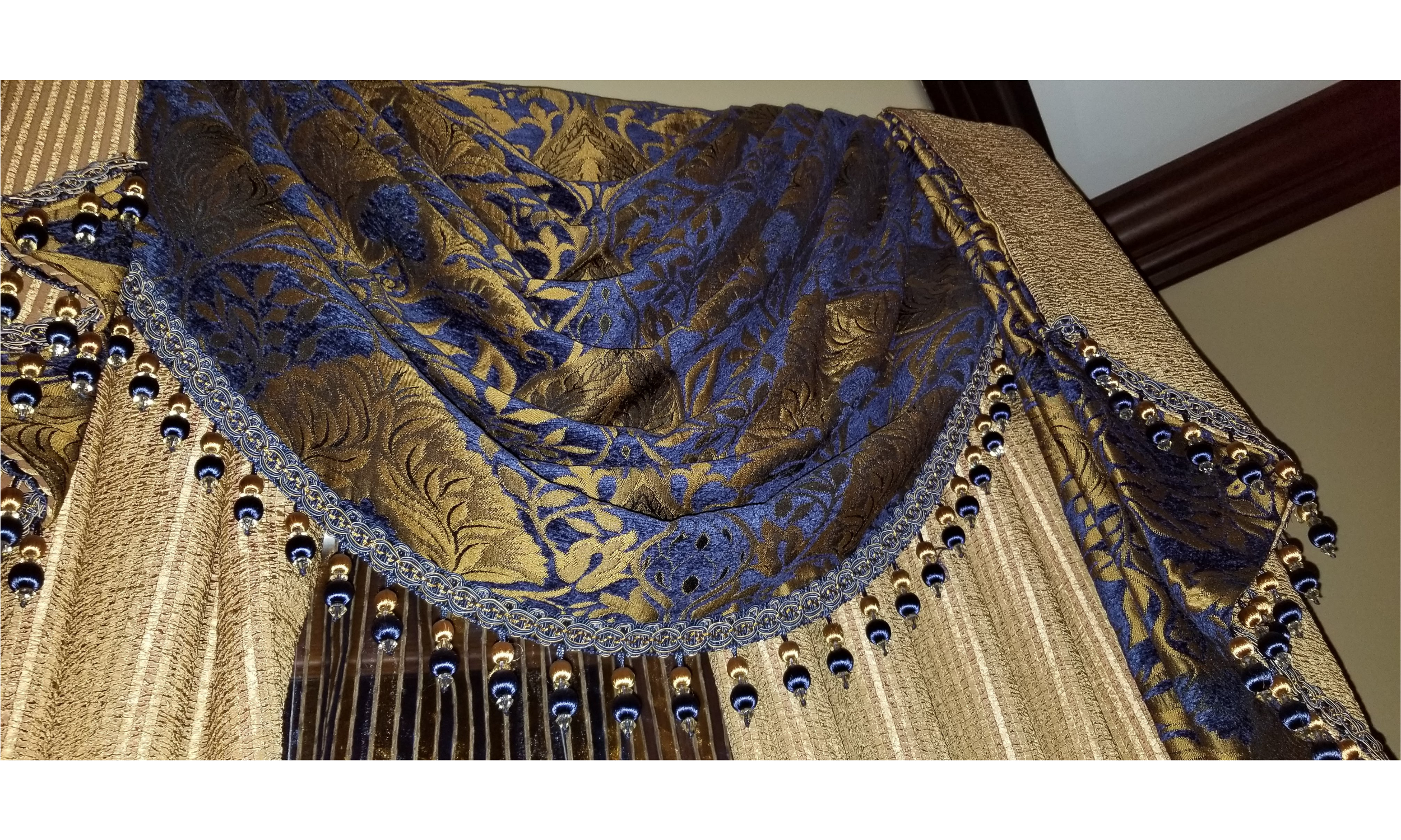 Custom Swags and Tails: A masterpiece of traditional window fabrication, featuring premium designer textiles and decorative tassel trim.