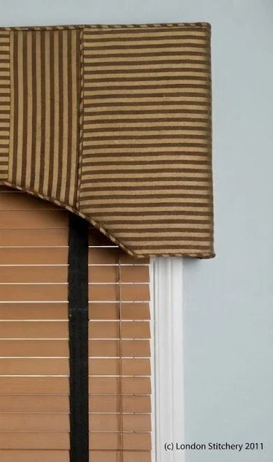 Custom-tailored valance featuring the matching striped fabric with a striking change in stripe direction, designed and crafted by London Stitchery.