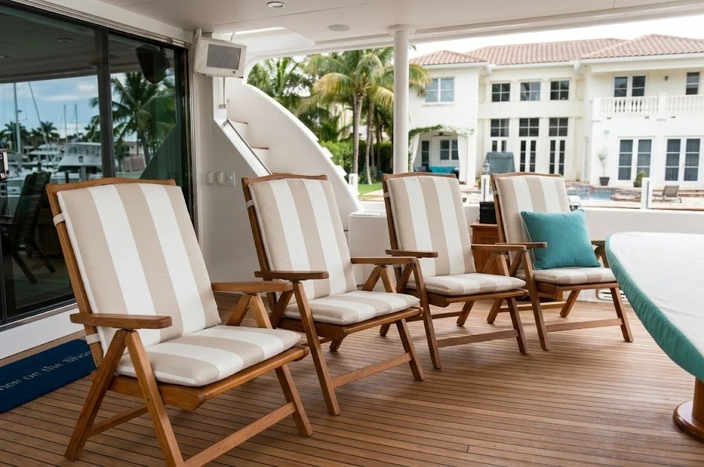 Custom teak deck chairs with striped marine cushions and yacht exterior furnishings handcrafted in Fort Lauderdale by London Stitchery.