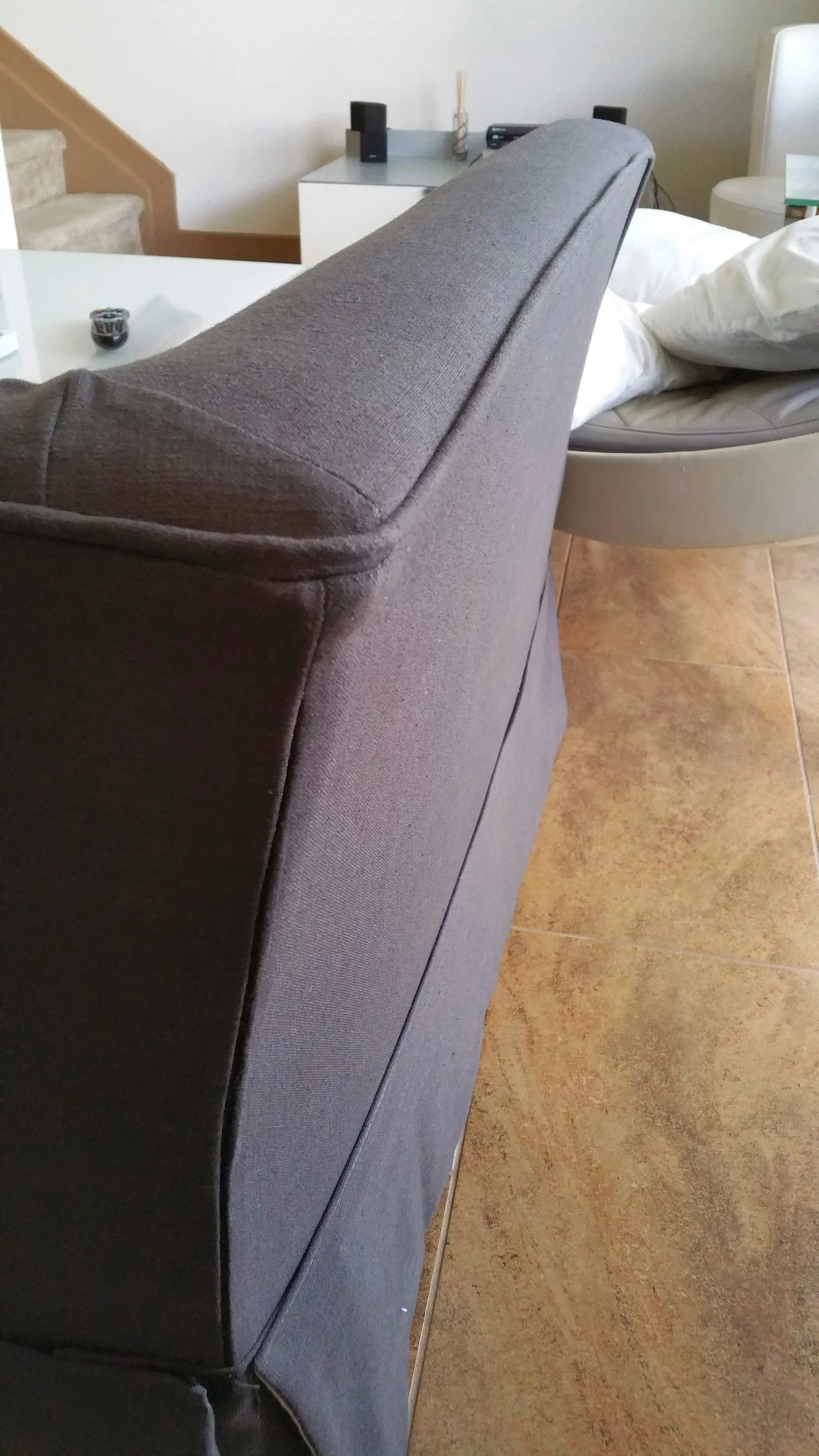 Tailored charcoal grey furniture slipcover showing an invisible zipper closure detail.
