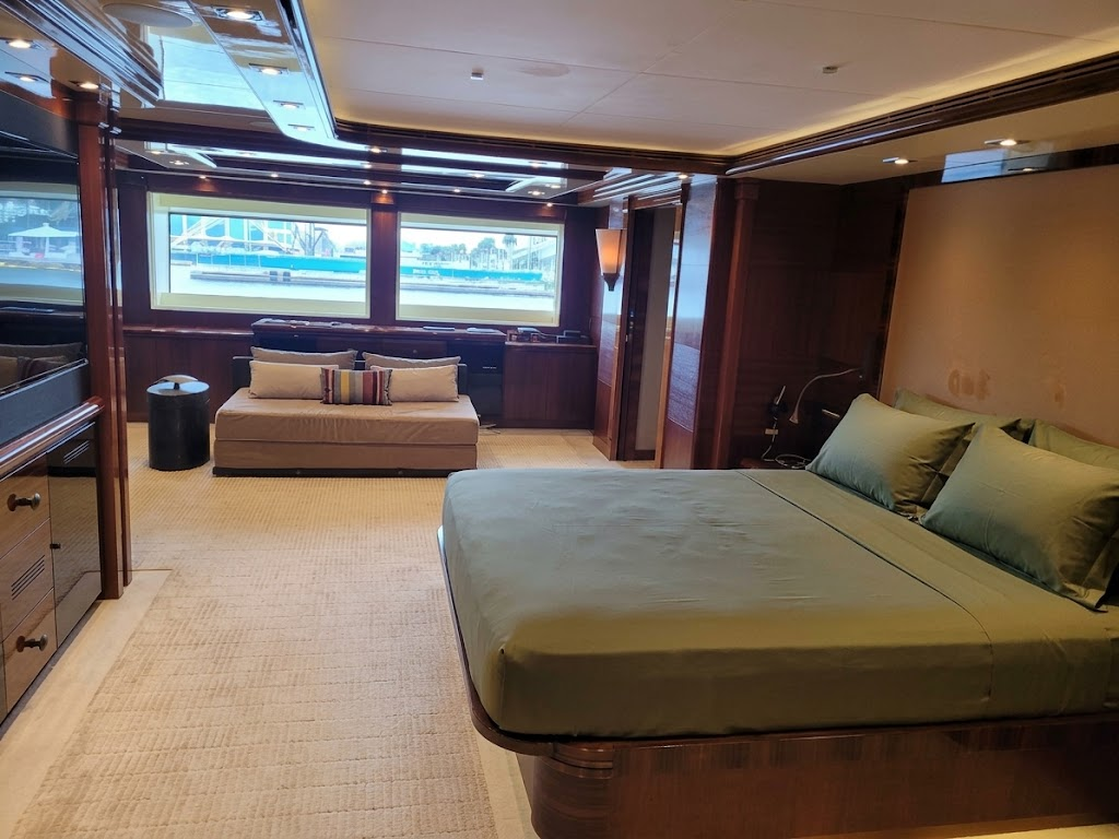 Custom green fitted sheets tailored precisely to fit the unique contour of the king-size mattress in a luxury yacht master stateroom, handcrafted by London Stitchery.