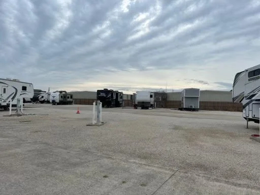 RV park with several parked RVs in an open lot under cloudy sky.