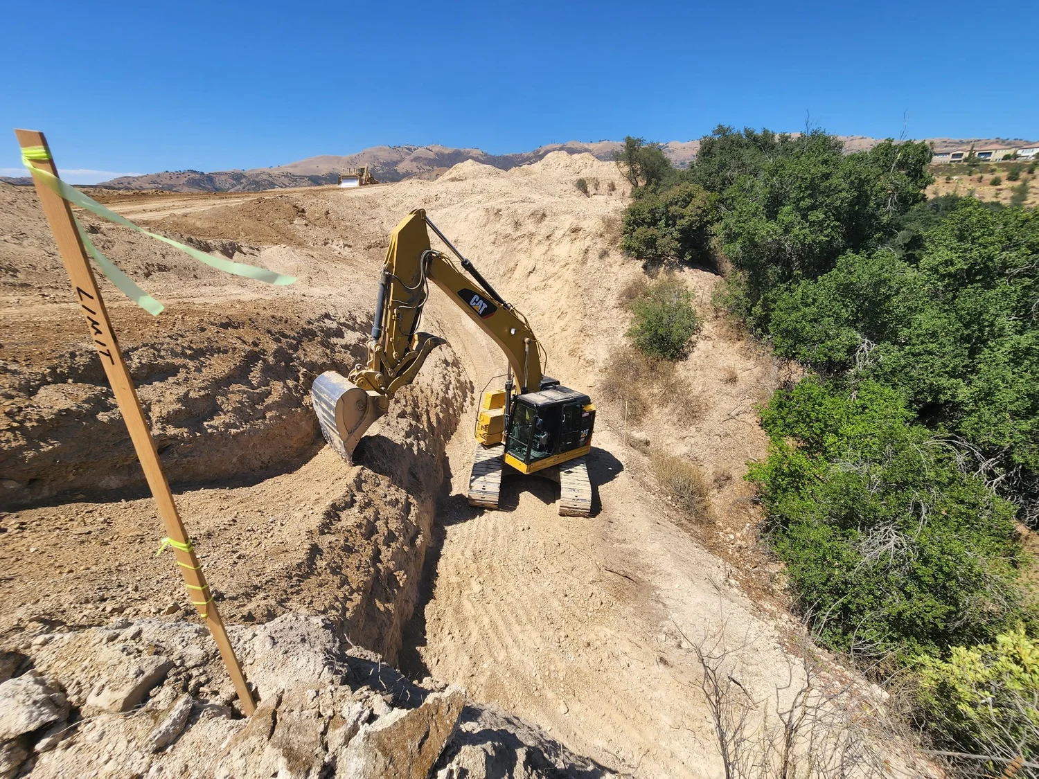 Excavator working along an open earthwork site