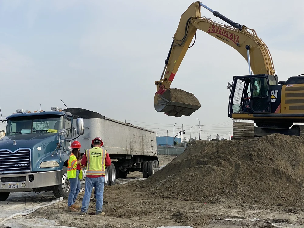 Excavator loading soil into a dump truck