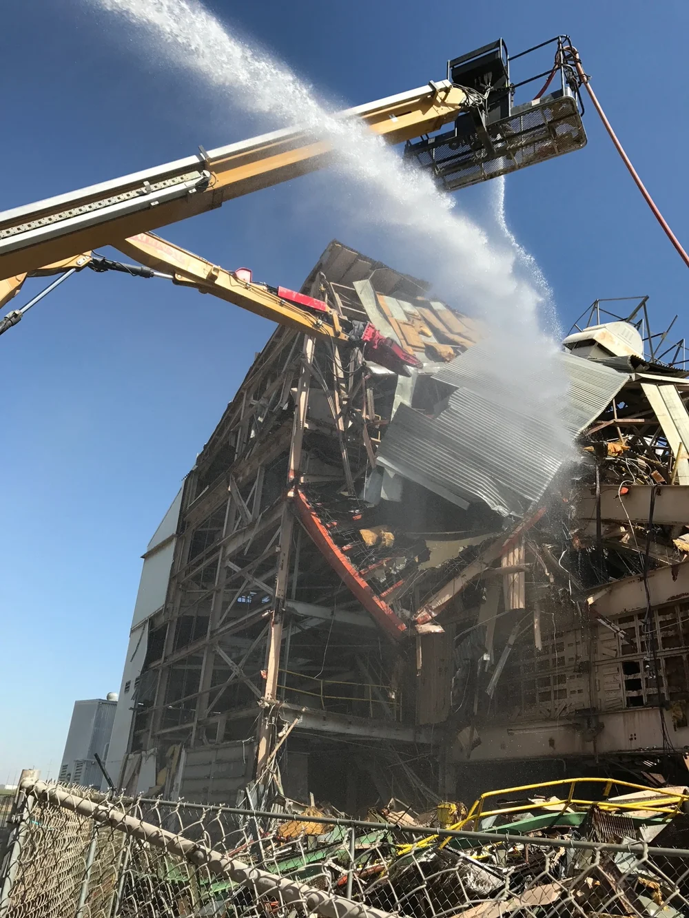 Demolition equipment working beside a water spray