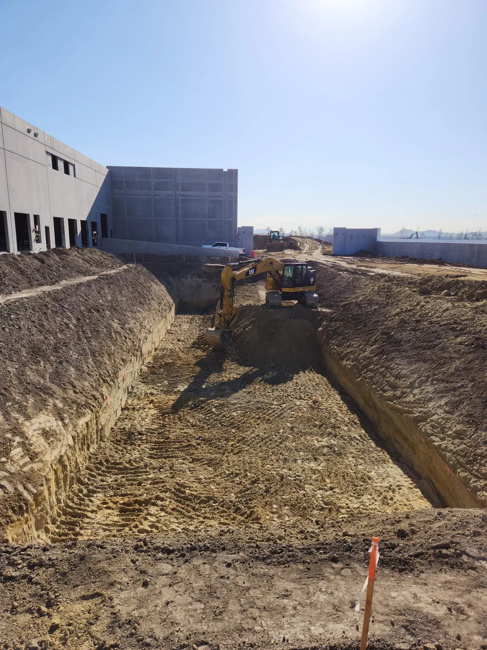 Earthwork and grading beside a large industrial building
