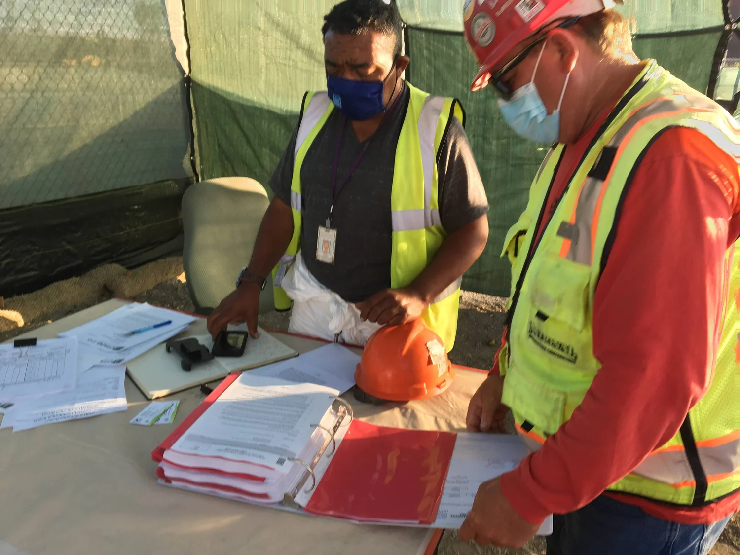 Two workers reviewing documents together in the field