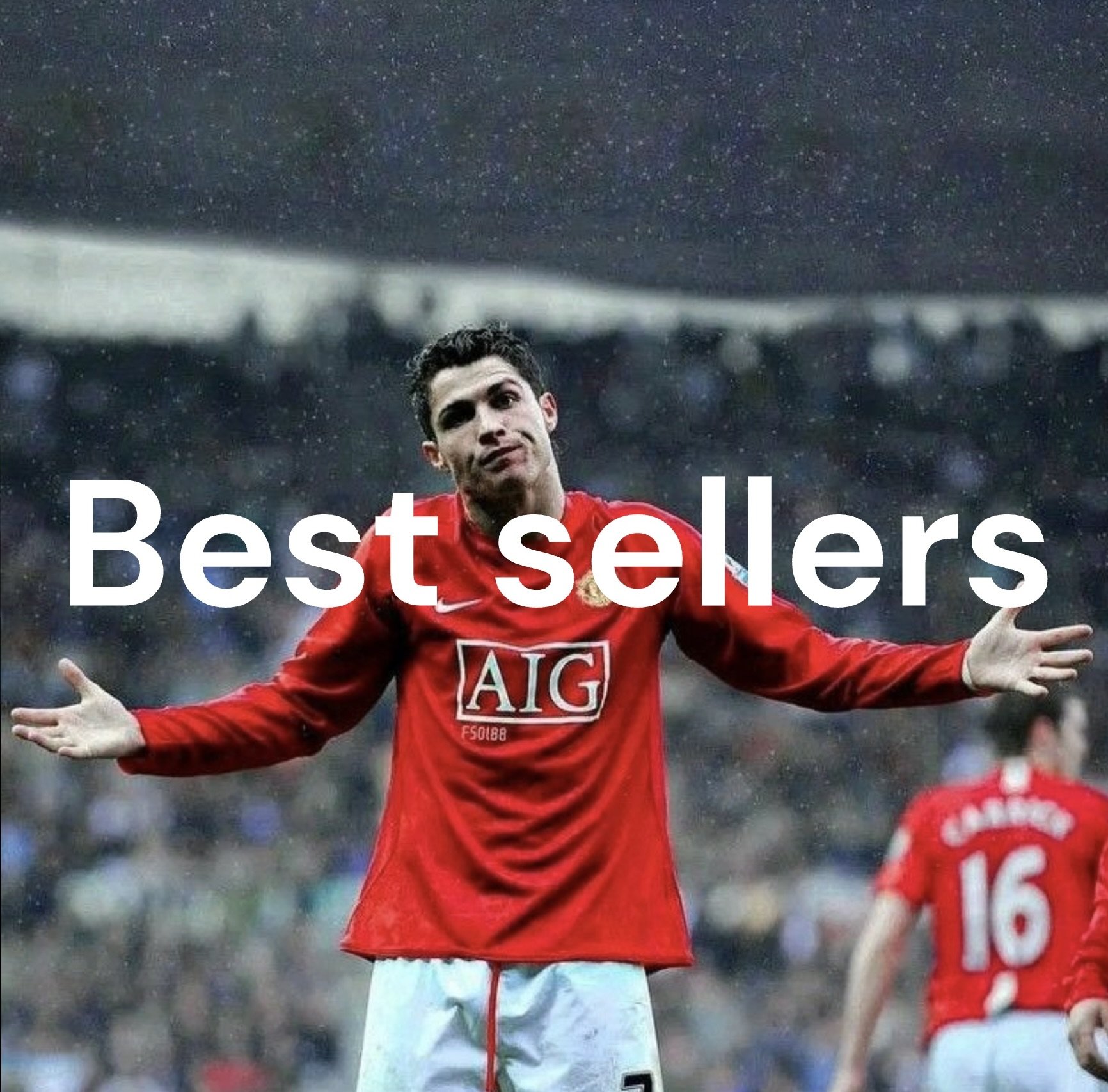 A soccer player in a red jersey with outstretched arms celebrating on the field, with another player in a red jersey in the background and stadium audience.