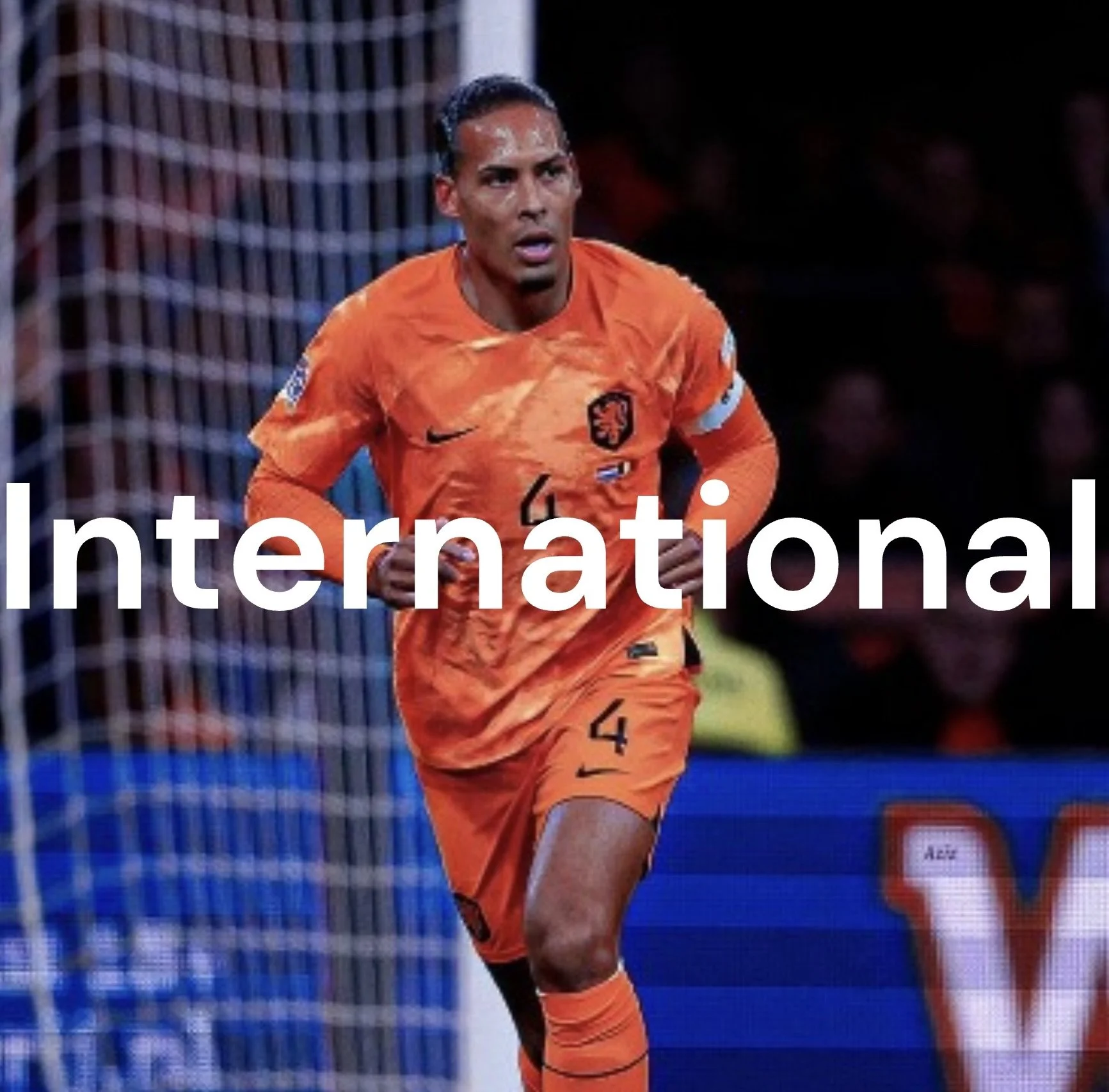 A soccer player in an orange jersey with the number 4, running on the field with a focus expression, with goal netting in the background.