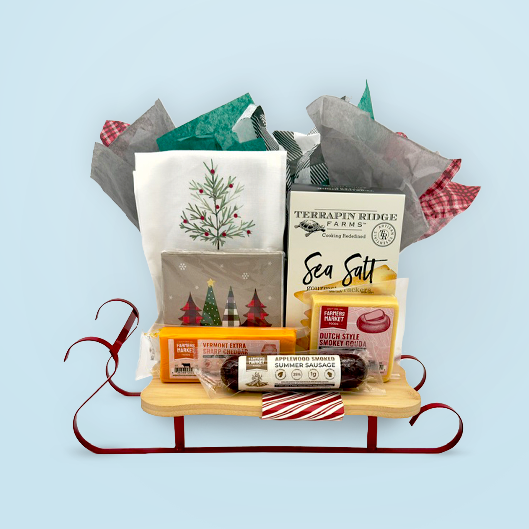 A festive sled-shaped charcuterie board with a variety of cheeses, sausages, & crackers makes a fun holiday gift! 
