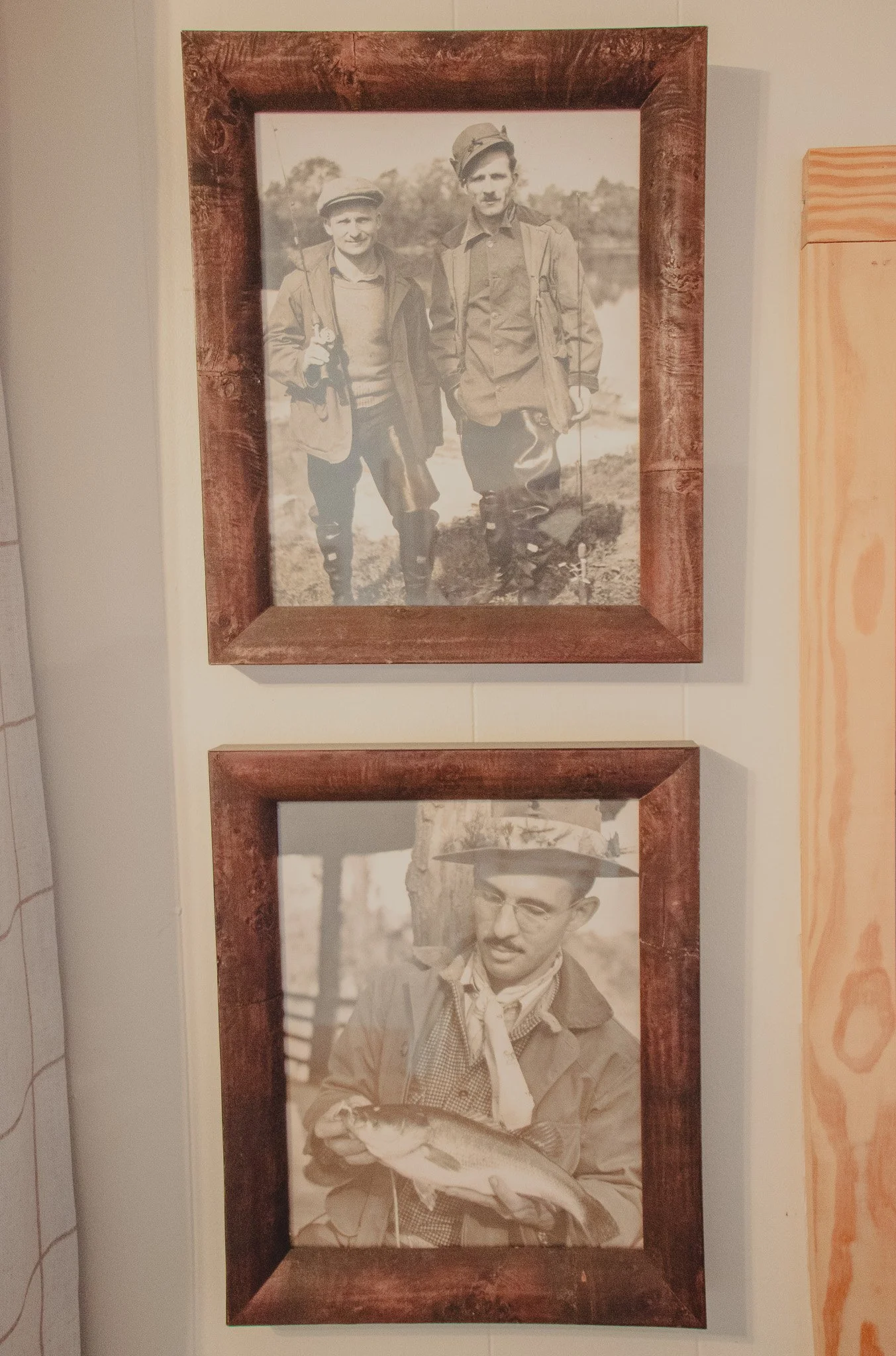 Two vintage photographs in wooden frames; the top photo shows two young boys in outdoor clothing holding fishing poles, standing on grass near a body of water, smiling at the camera; the bottom photo shows a man with glasses, a hat, and a scarf aroun