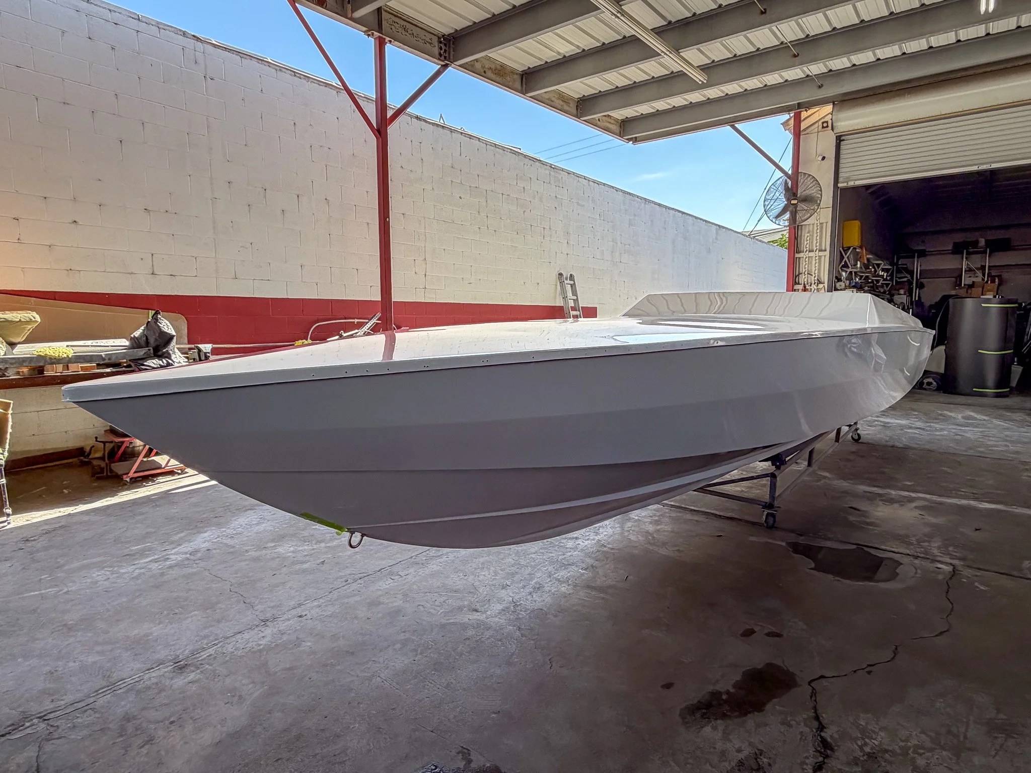 a boat hull made from fiberglass inside of a boat shop