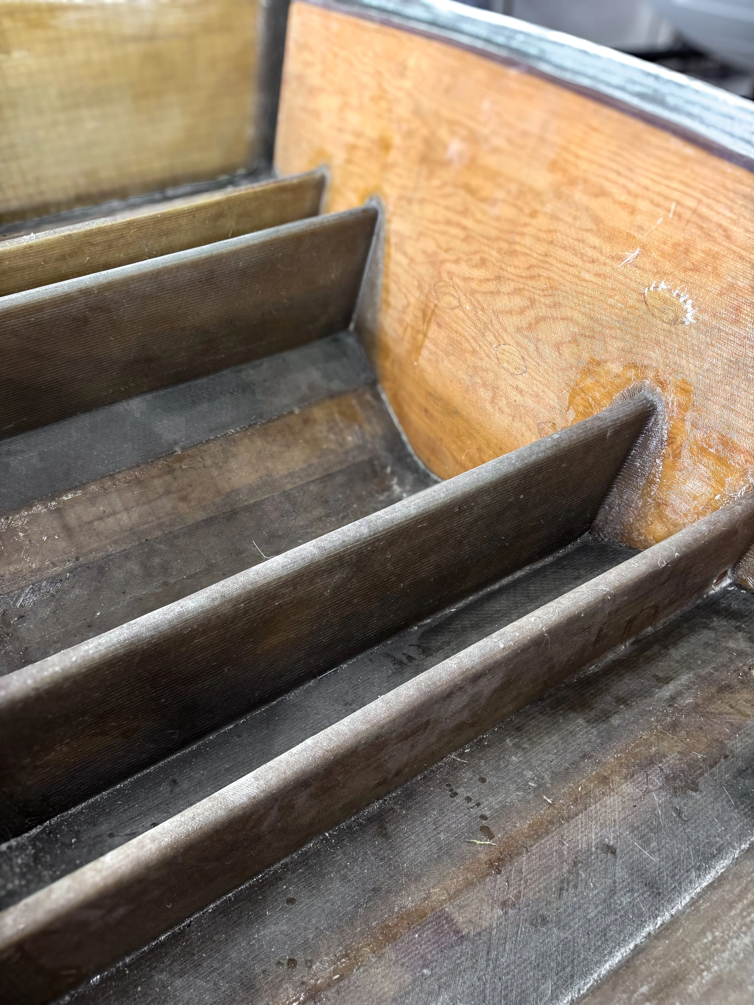 inside of a boat hull showing the transom with wood, fiberglass, and coring