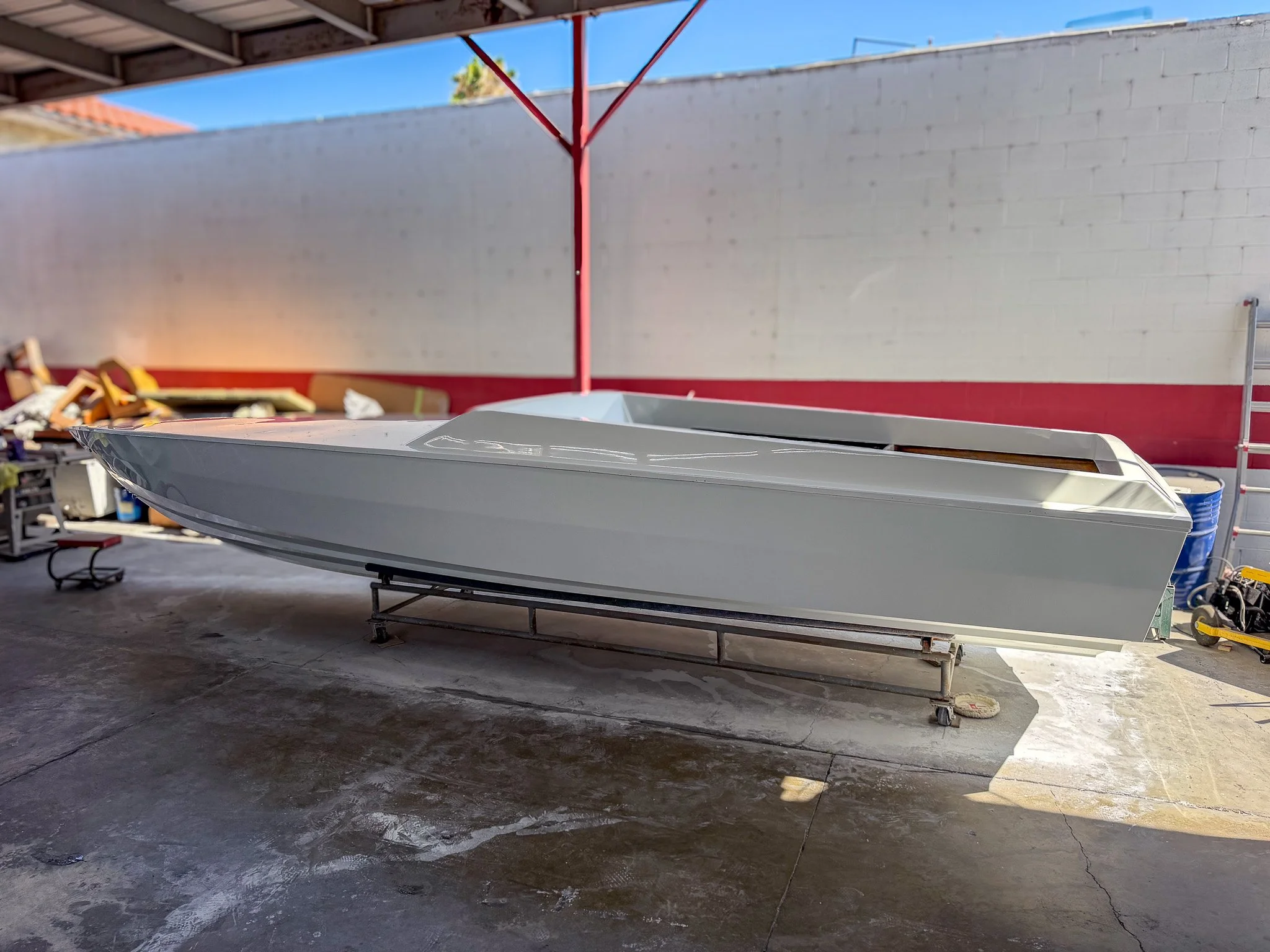 a boat hull made of fiberglass inside of a boat shop