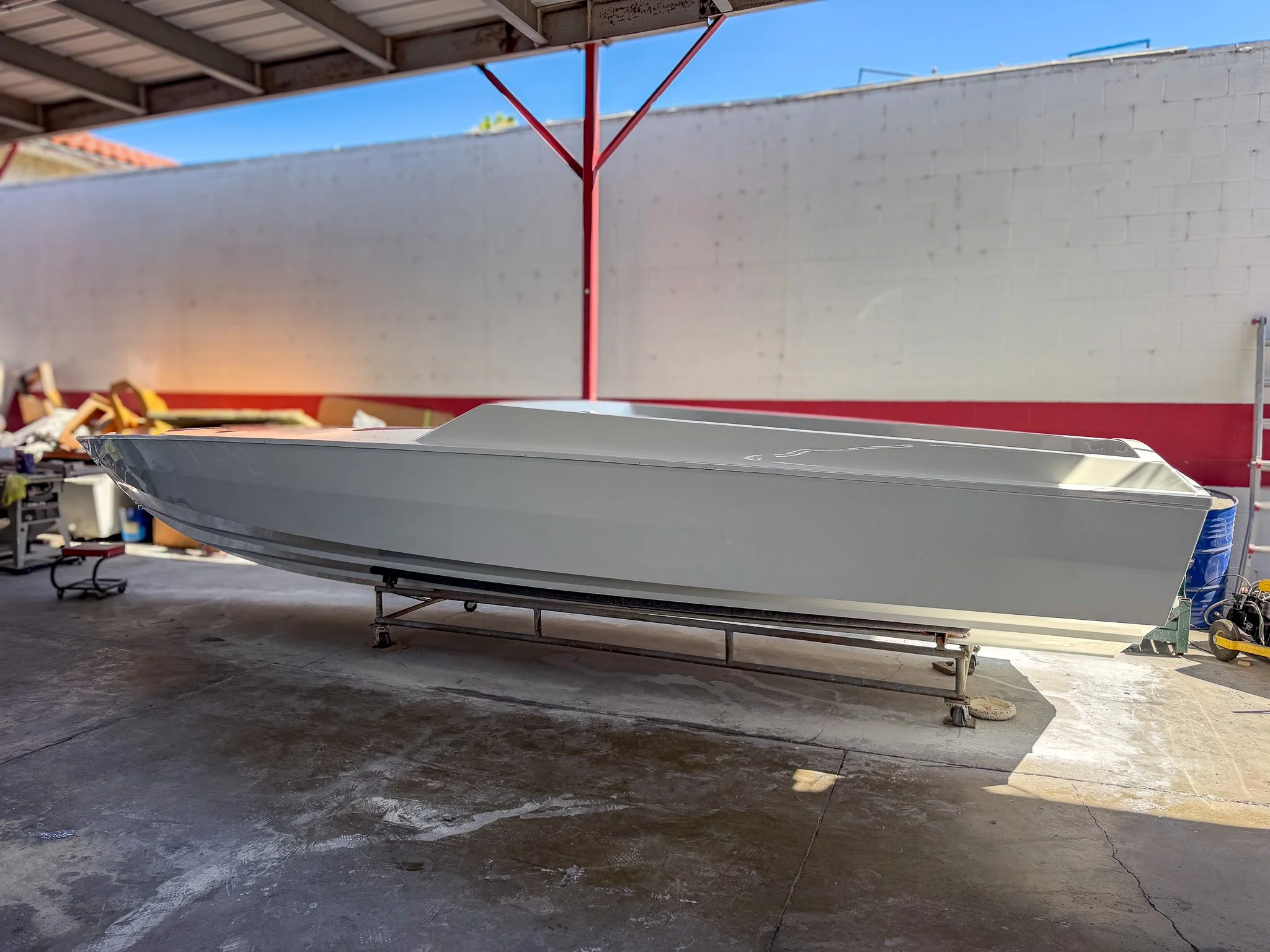 an empty boat bull inside of a boat repair shop