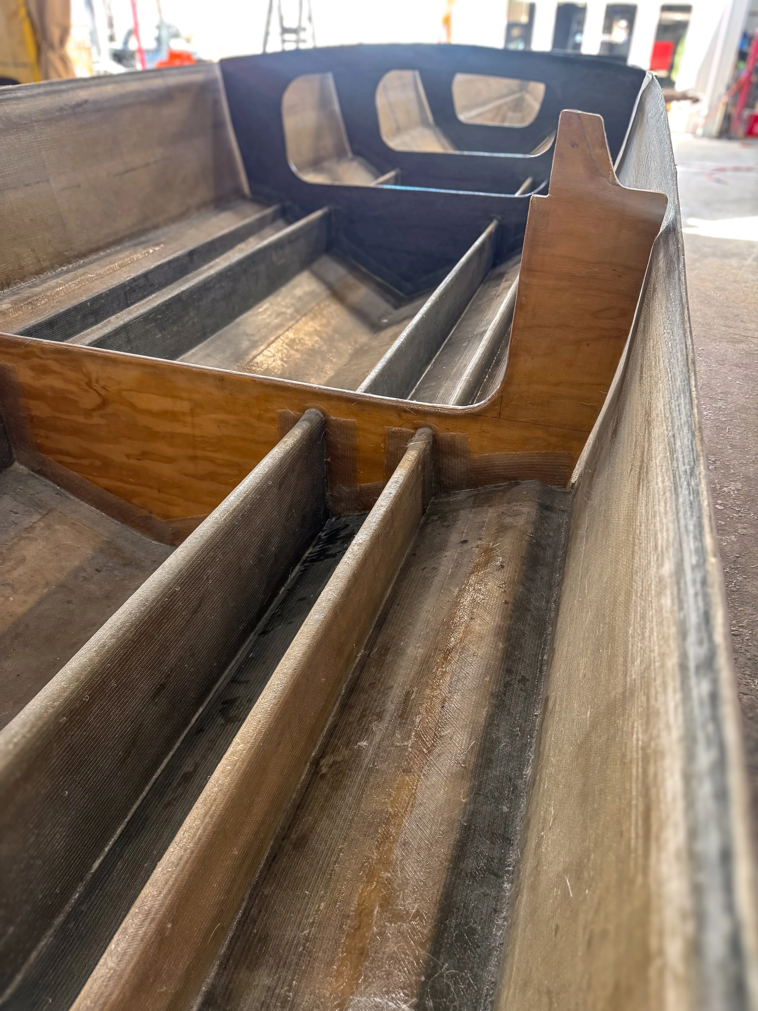 close up of the inside of a boat hull showing stringers, bulkheads, fiberglass and coring