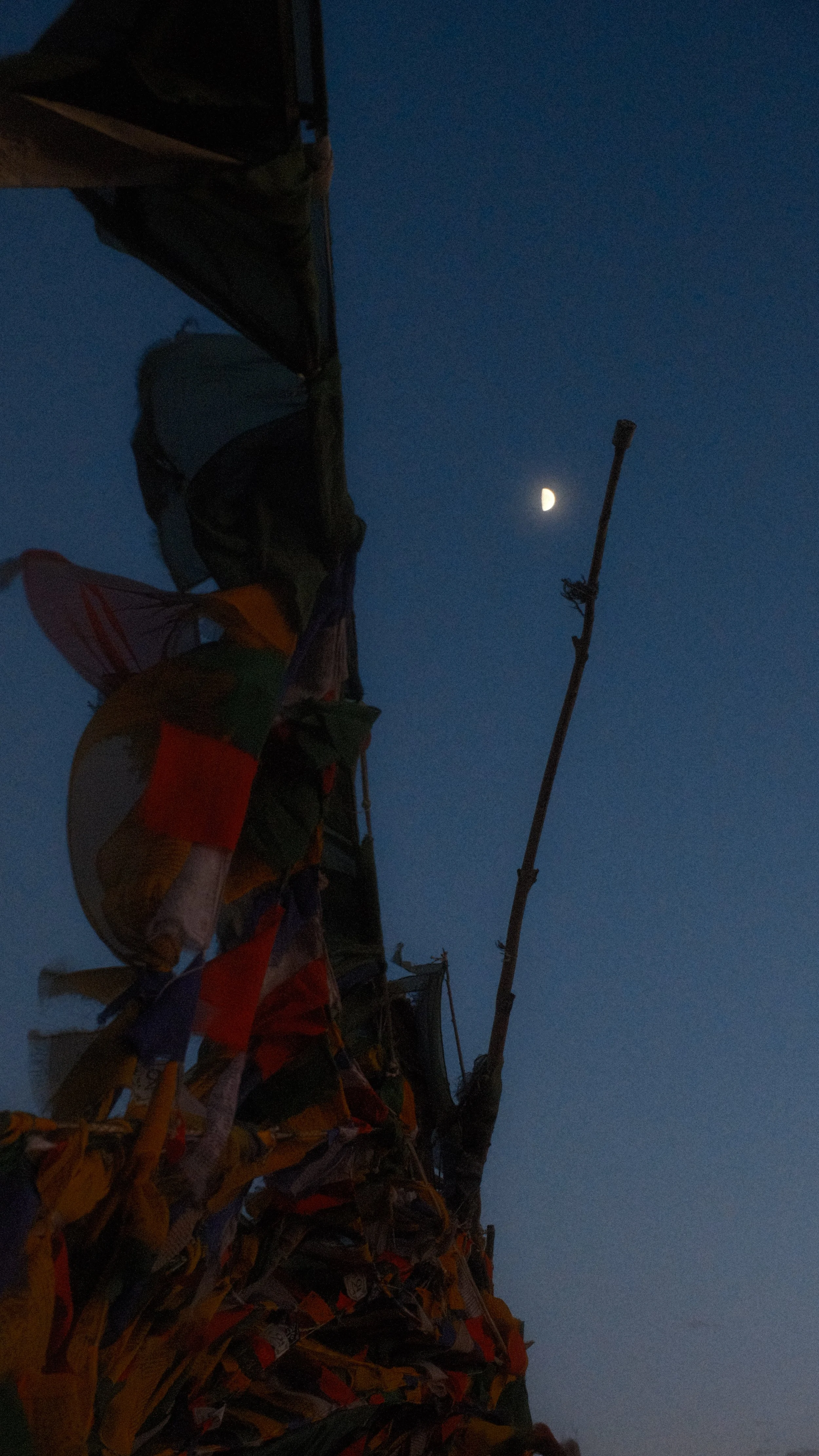 Bandera ycloths en un mástil con la luna en el cielo oscuro.
