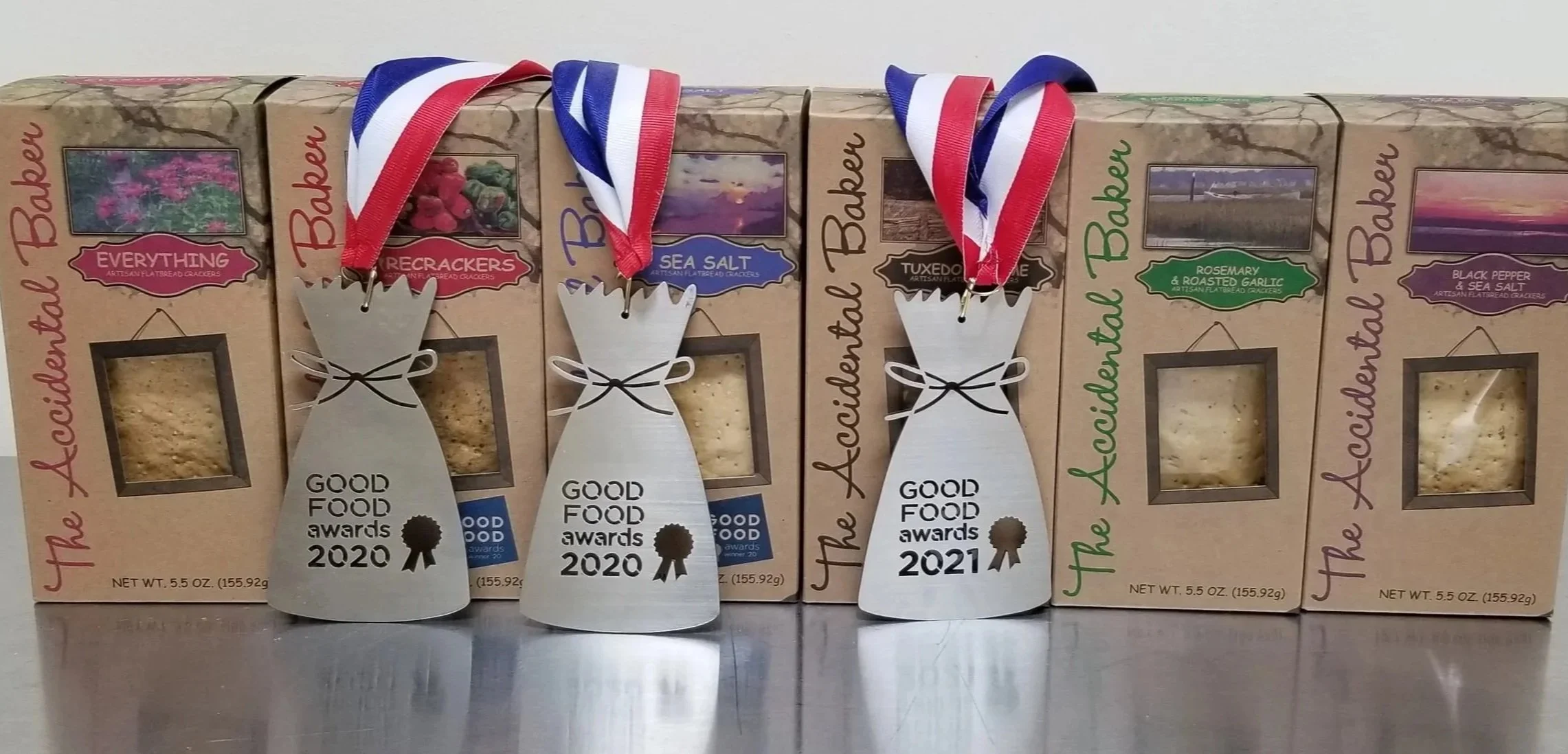 All six flavor of The Accidental Baker's artisan flatbread crackers. Everything, Firecrackers (with a Good Foods Award), Sea Salt (with Good Foods Award), Tuxedo Sesame (with Good Foods award), Rosemary & Roasted Garlic, Black Pepper