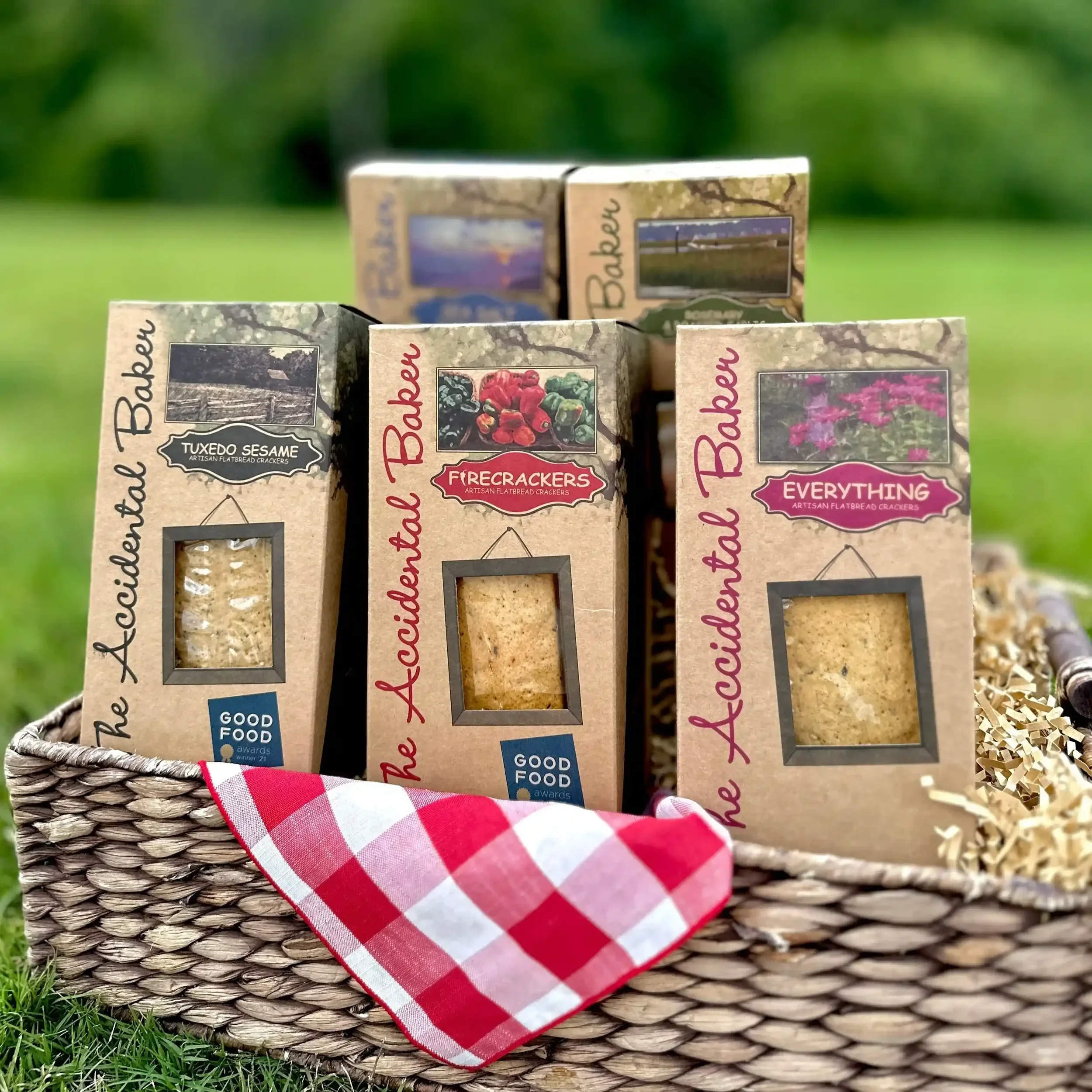Boxes of The Accidental Baker's artisanal flatbread crackers in a picnic basket
