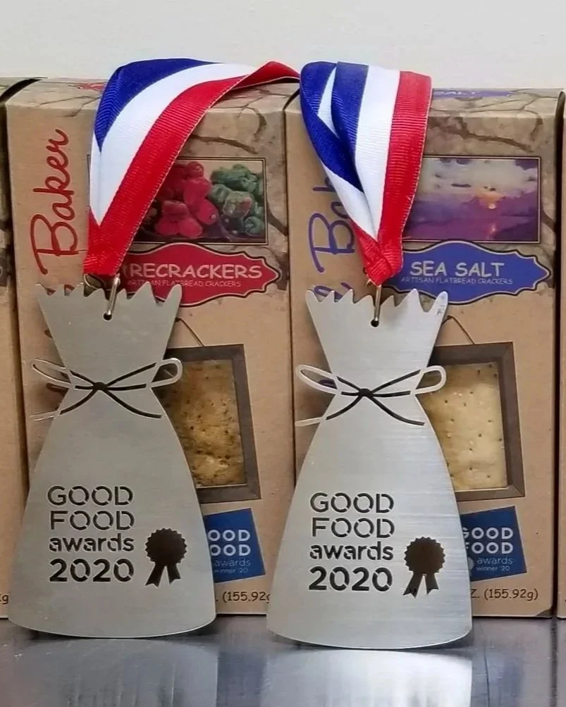 The Accidental Baker's Firecracker and Sea Salt artisan flatbread crackers pictured with their Good Food Award Medals for 2020.