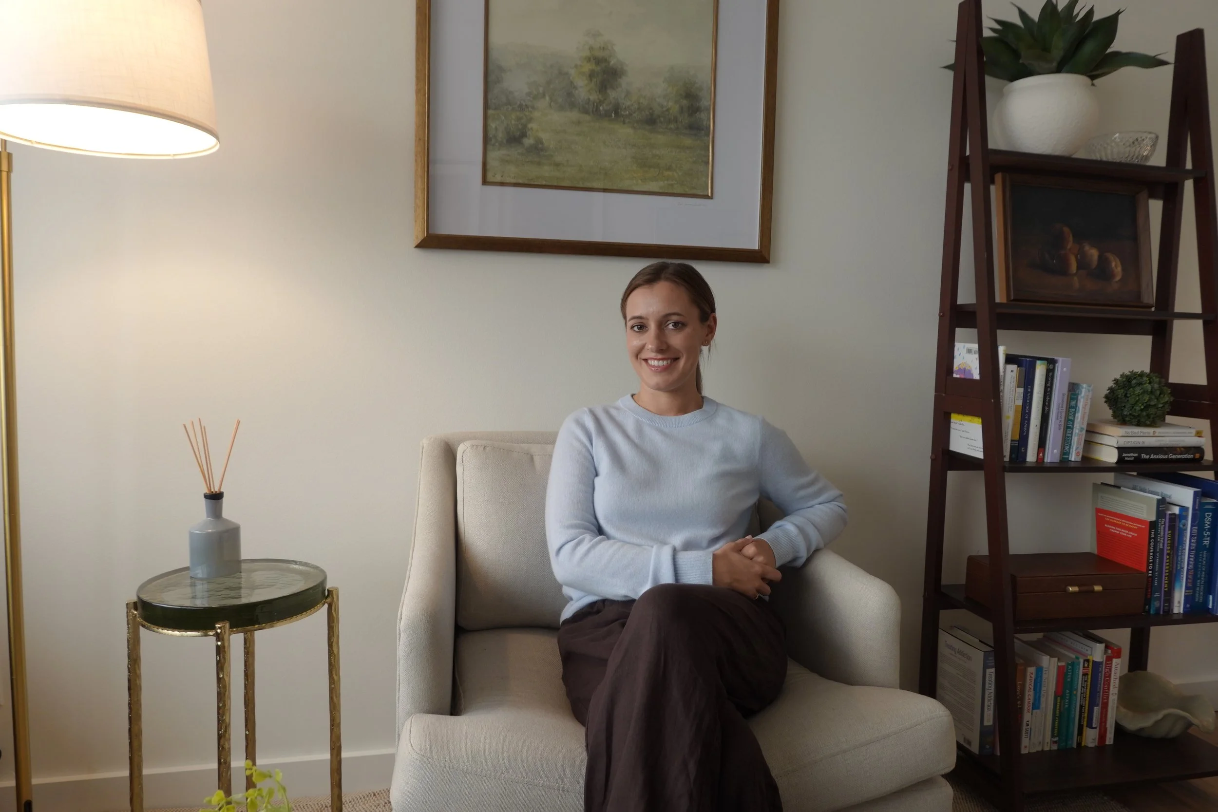 Sarah Stewart, MSW, LSWAIC, a therapist in Seattle, smiling warmly in a bright, softly lit portrait