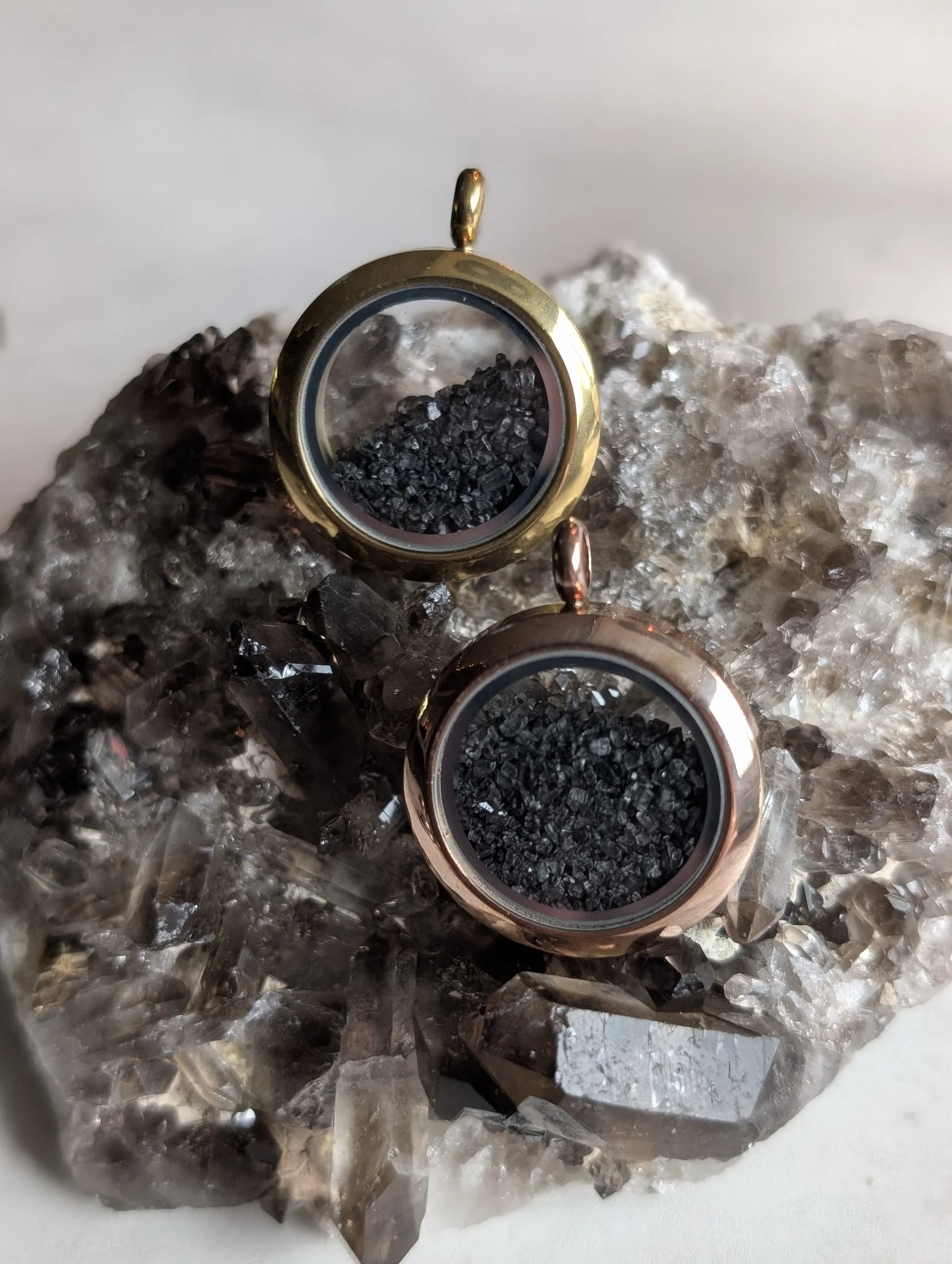 Protection Lockets of in colors of gold and rose gold filled with black salt.