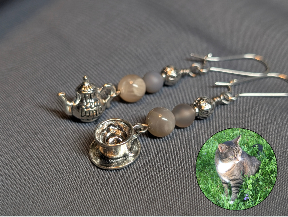 A coffee and teapot earring set with Moonstone and Gray Chalcedony. Inset with an image of a cat named Pippi. 