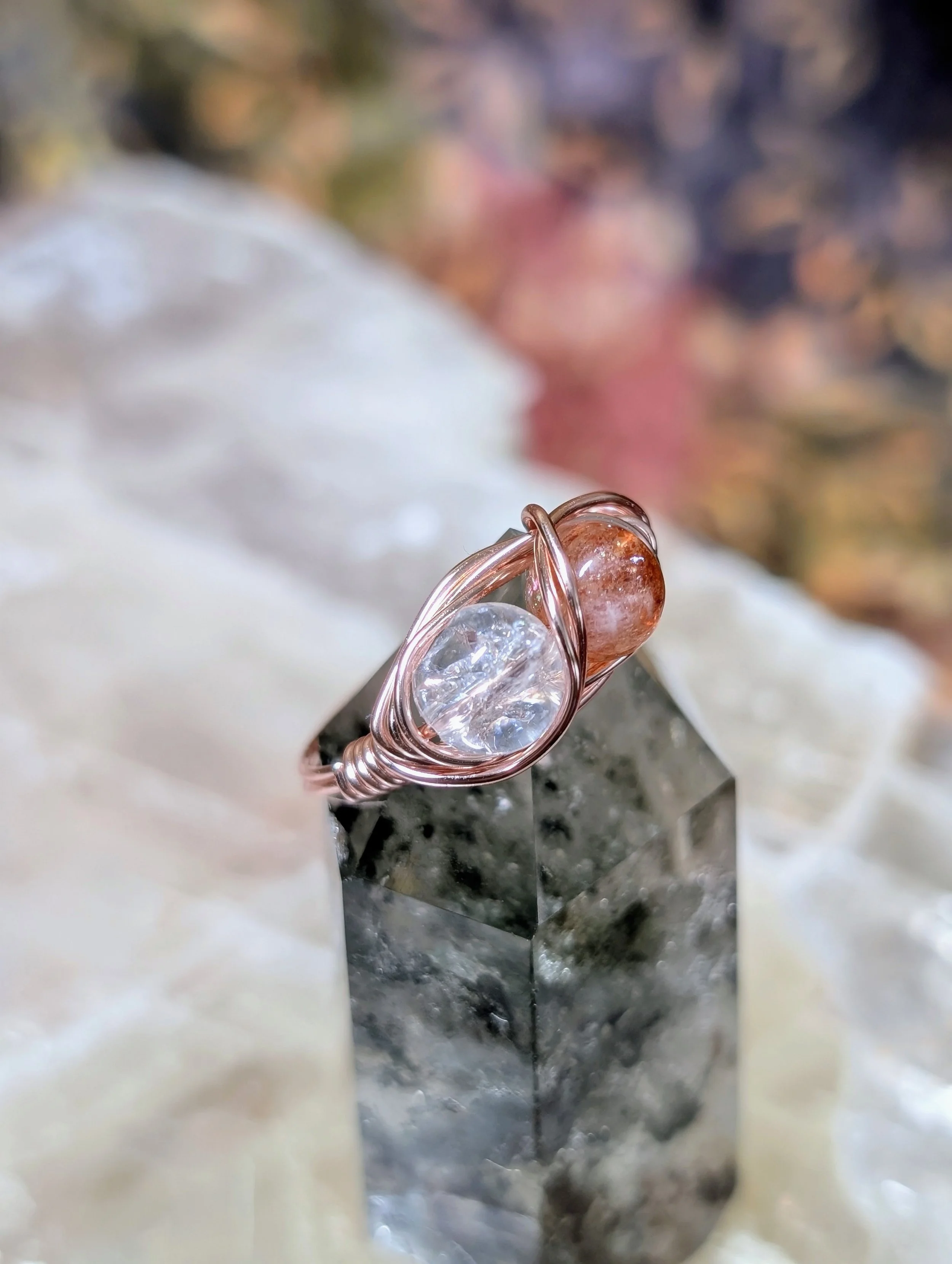 A ring in rose gold colored metal with fire quartz and sunstone