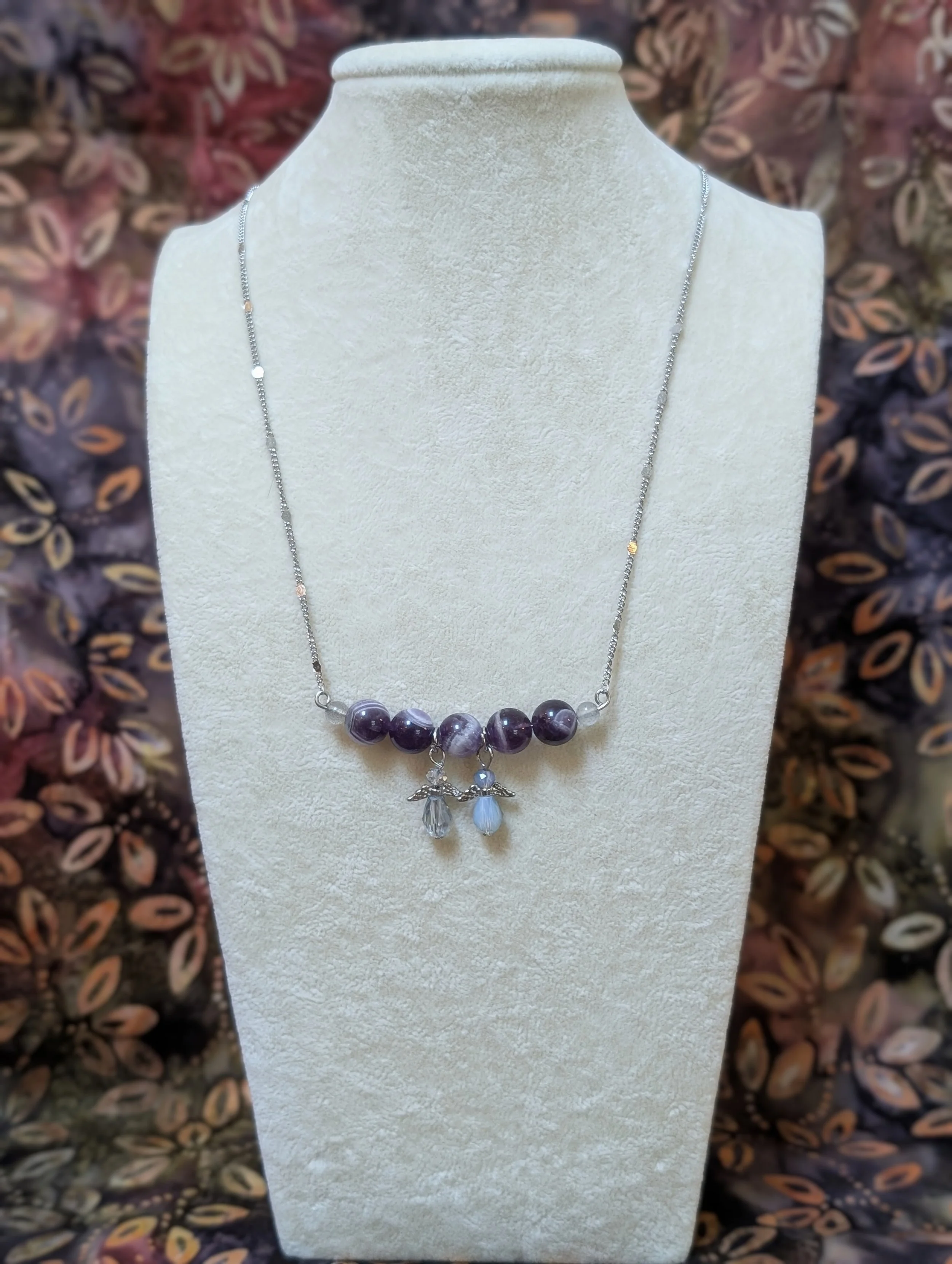 A necklace made of small labradorite end beads with purple amethyst and 2 angel accents