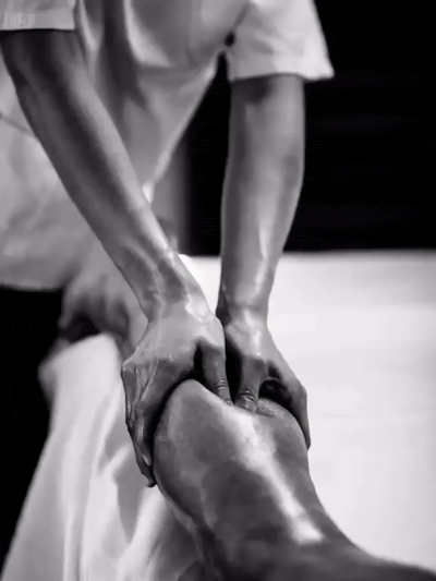 Therapist applying pressure to a client's knee during sports massage