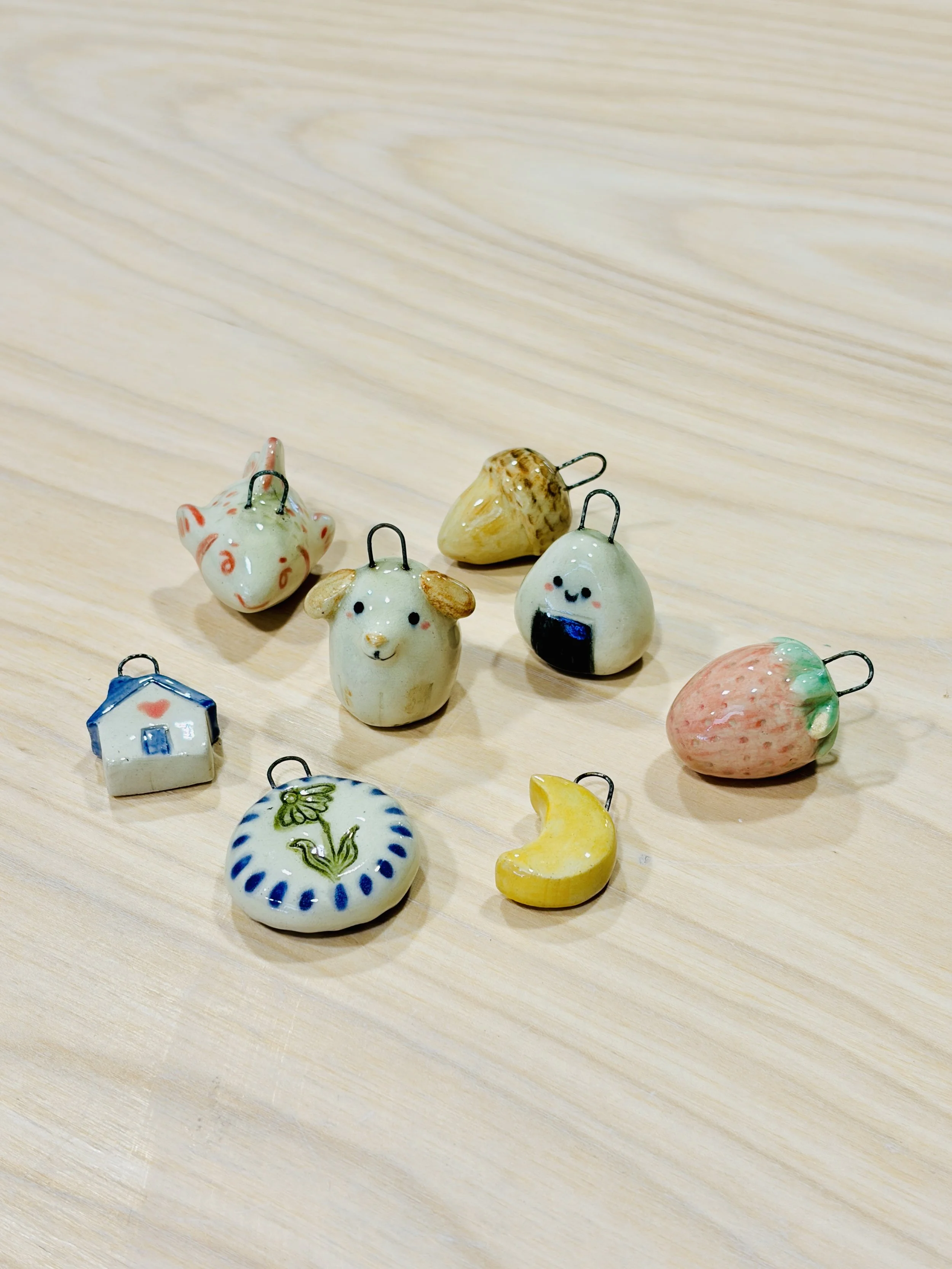 A collection of colorful ceramic mini charms on a wood table