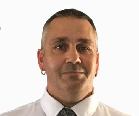 Headshot of a man with short dark hair, wearing a white shirt and a dark patterned tie, against a plain white background.