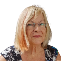 A portrait of an older woman with shoulder-length blonde hair, glasses, and a floral top, looking at the camera against a white background.