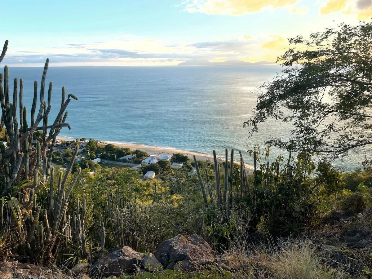 The view of Crabbe Hill Village and Beach from the top of the hill with expansive views across the Caribbean Sea to Monserrat and of the white sand beach.