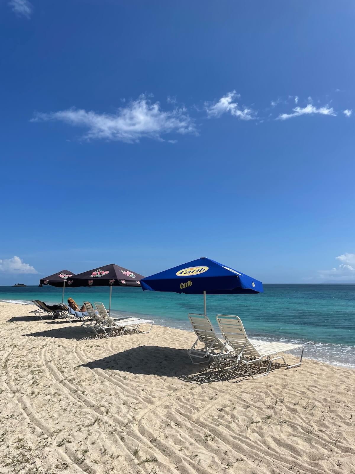 Sun loungers on Crabbe Hill Beach with white sand and turquoise sea, 1 minute from the studio for The Sea Change Retreat, your place to relax and dream your New Era into being.