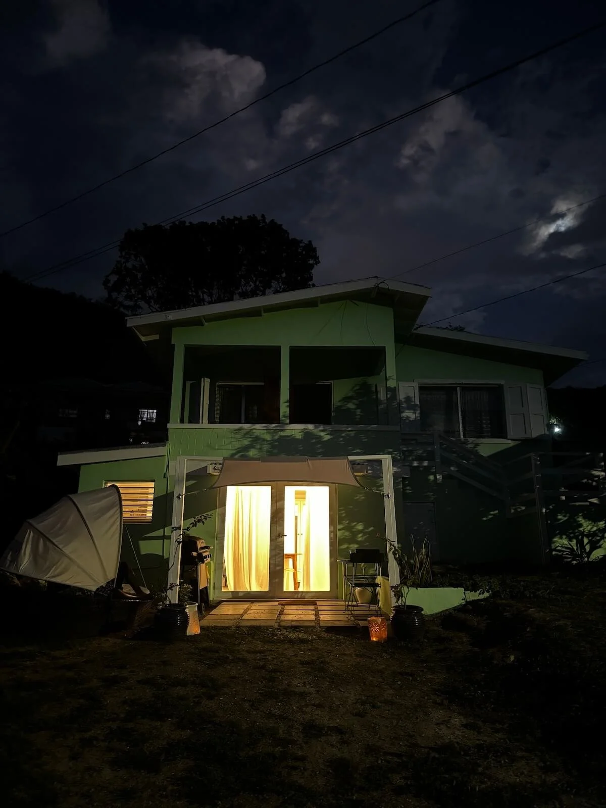 The Studio, your home on The Sea Change Retreat with Kat, lit up at night, warm and inviting.