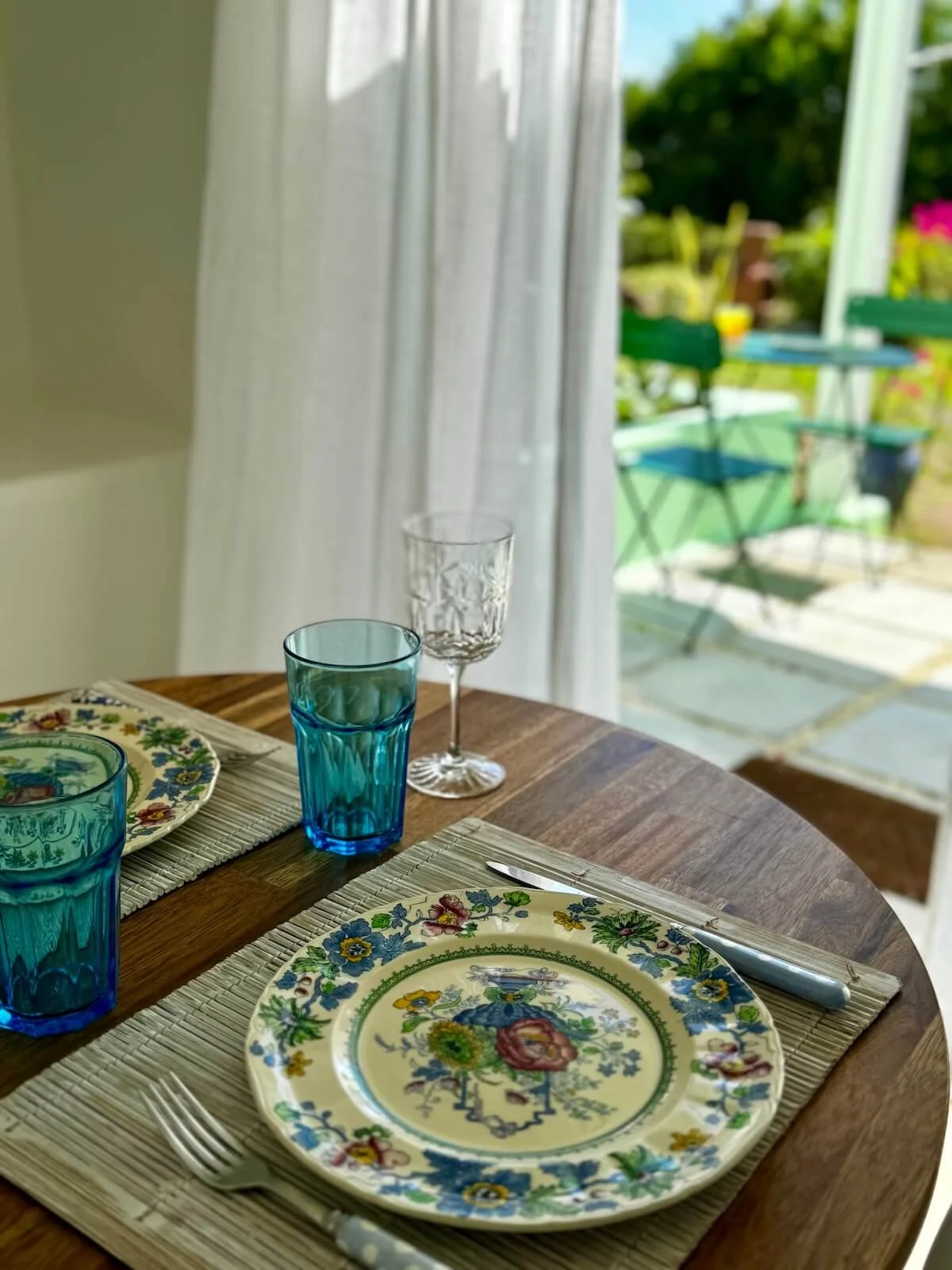 Dining table set with Mason plates, wine glasses with a view of the outdoor patio at the studio in Crabbe Hill, your home on The Sea Change Retreat with Kat