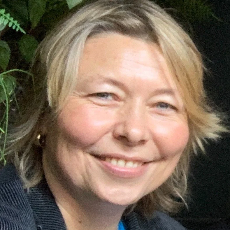 Close-up of Wendy Richmond, smiling, outdoors near green foliage, a former client of Kat Byles