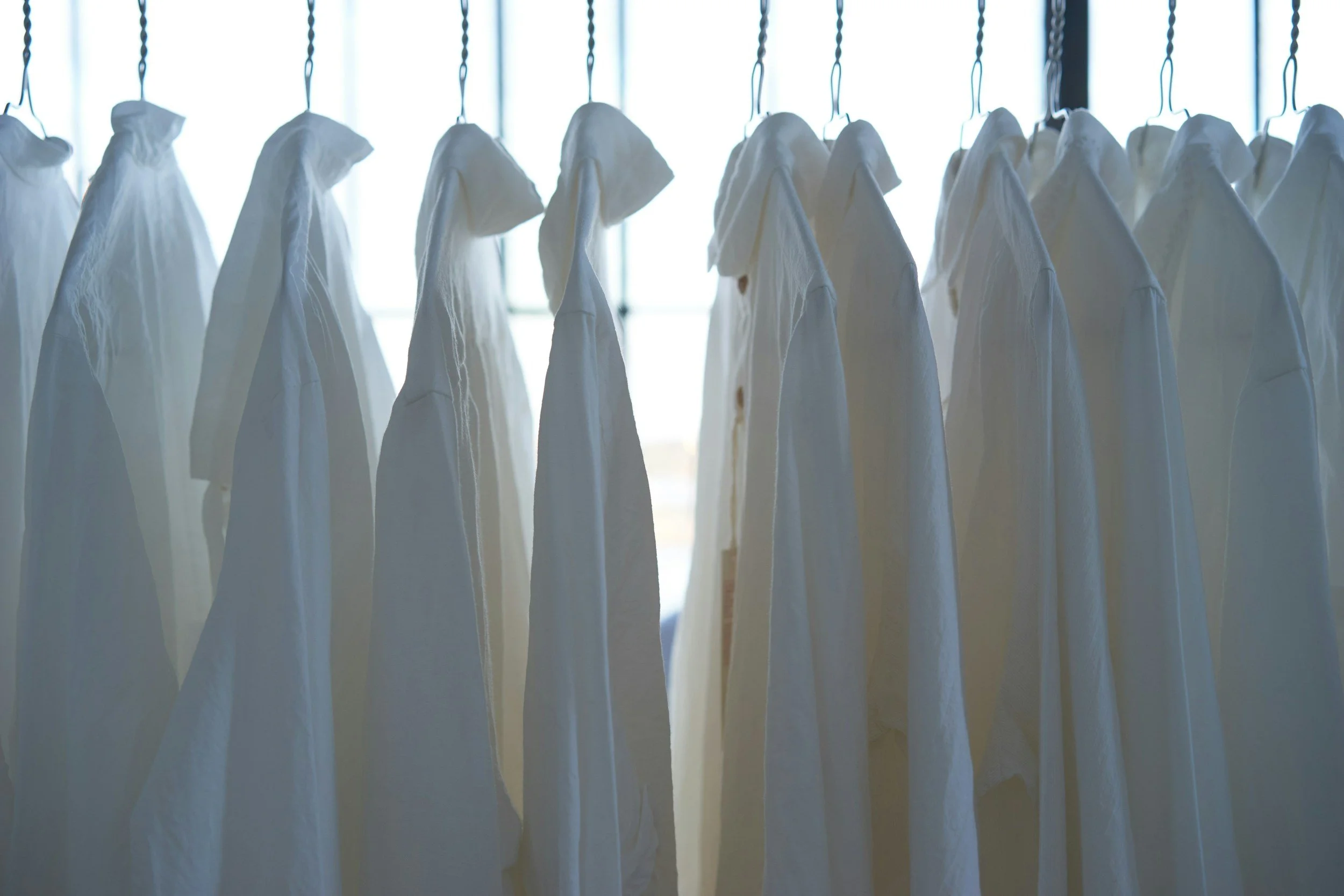 Crisp white shirts hanging neatly — symbolizing GoodMaids’ professional housekeeping and reliable laundry support.